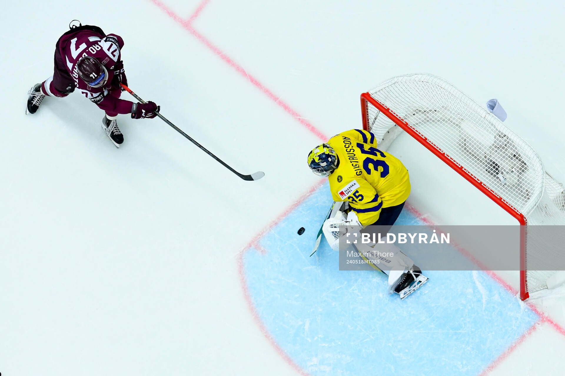 Roberts Bukarts of Latvia and goaltender Filip Gustavsson