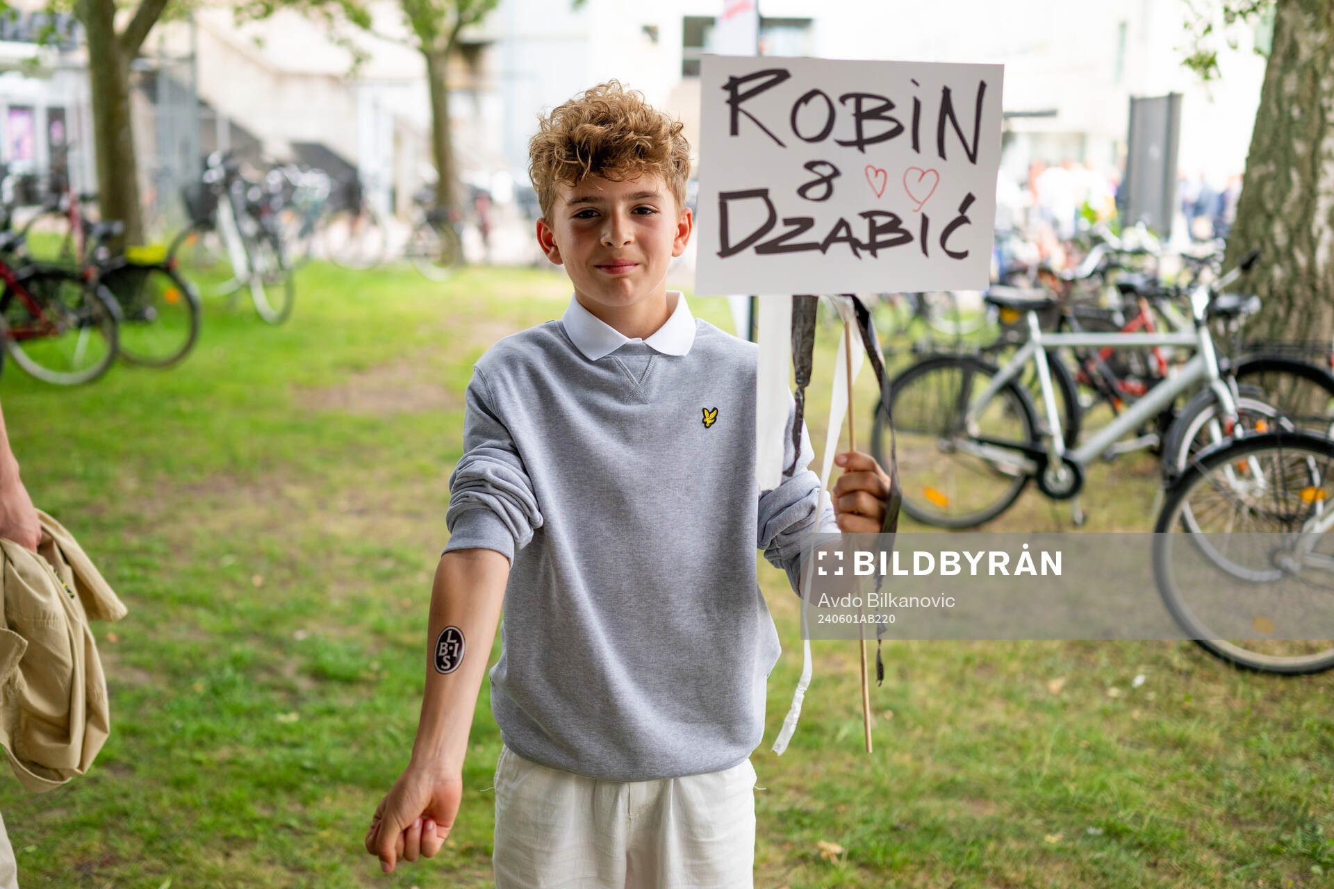 En ung kille med skyllt och tatuering på handen