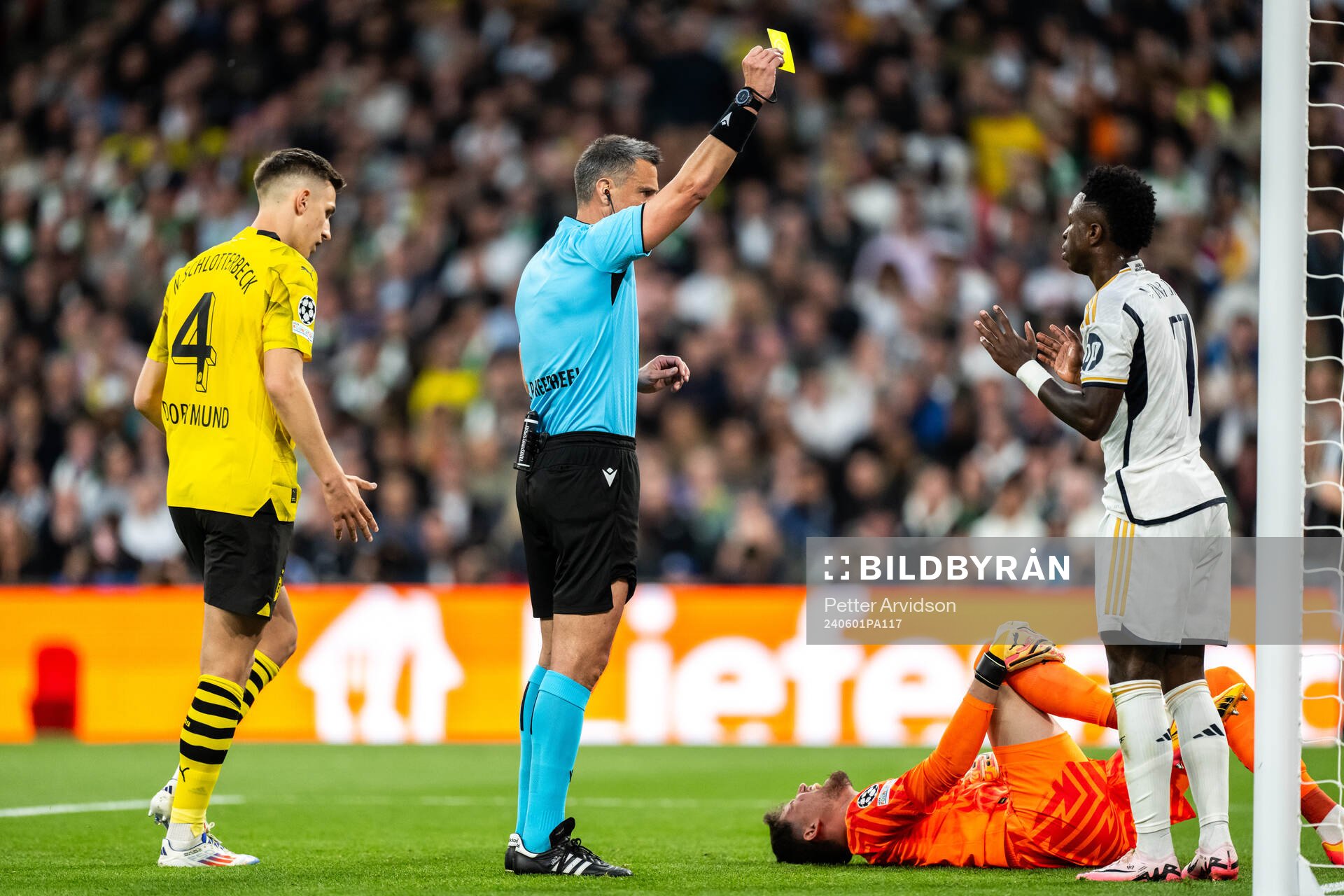 Vinicius Junior of Real Madrid receives a yellow card