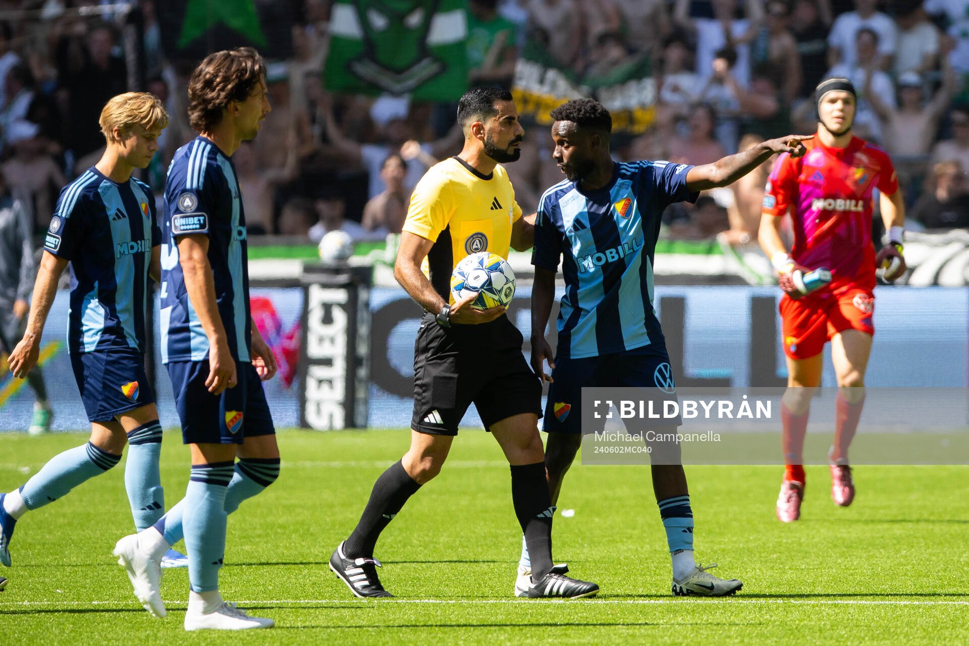 Djurgårdens Tokmac Nguen och Domare Mohammed Al-Hakim under fotbollsmatchen i Allsvenskan mellan Djurgården och Hammarby den 2 juni 2024 i Stockholm.