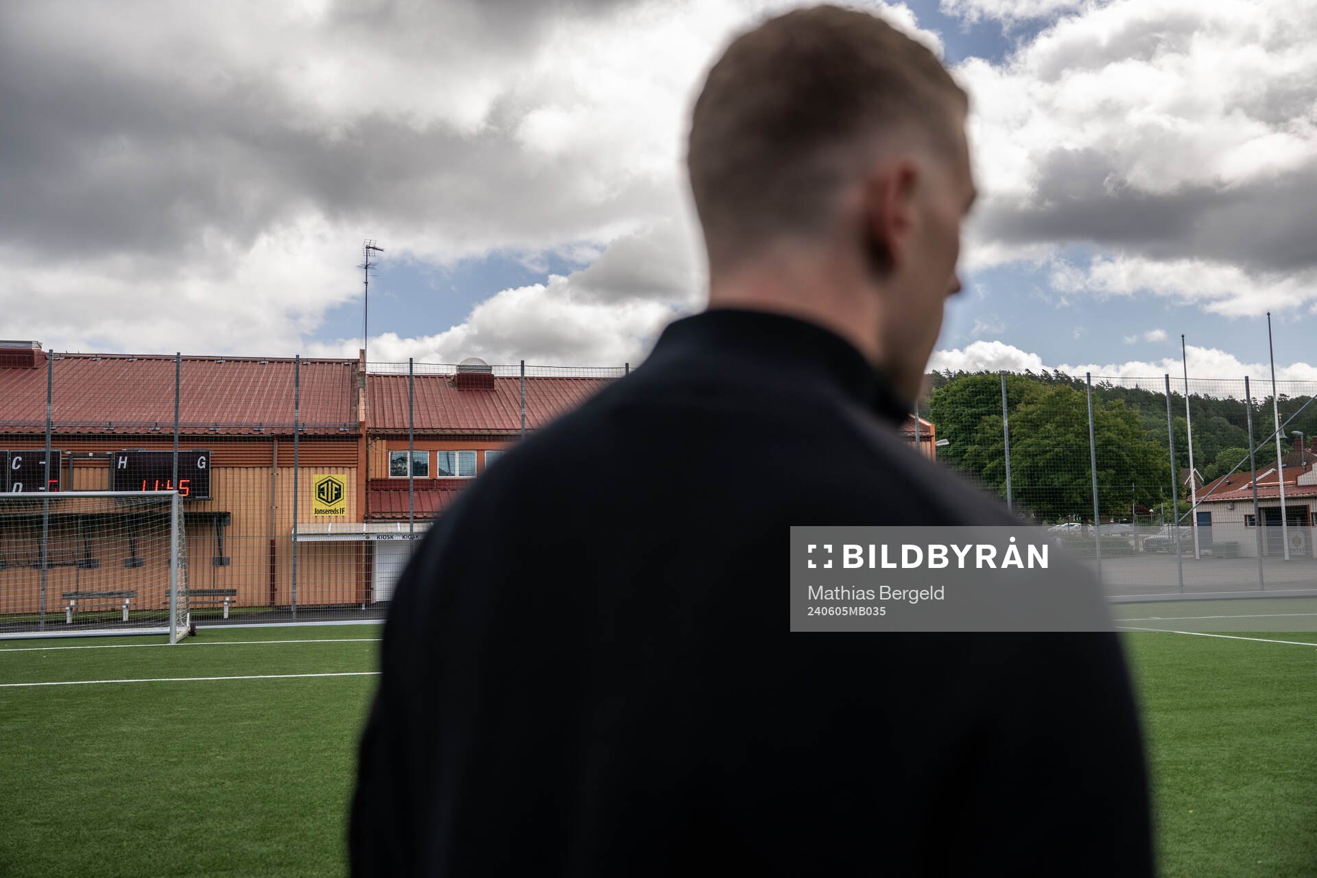 s logotyp syns på en byggnad på Jonsered IP bakom