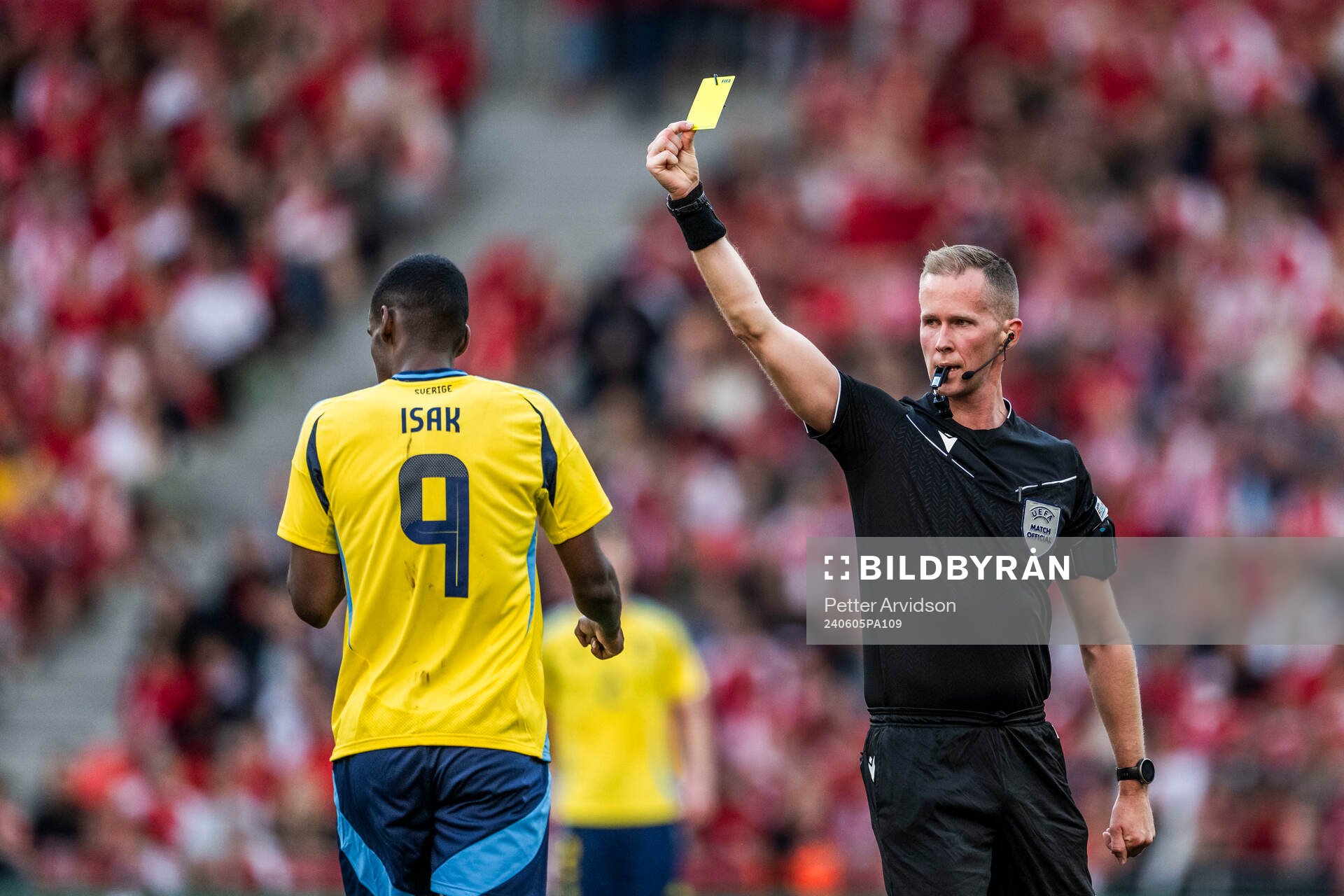 Alexander Isak of Sweden receives a yellow card from