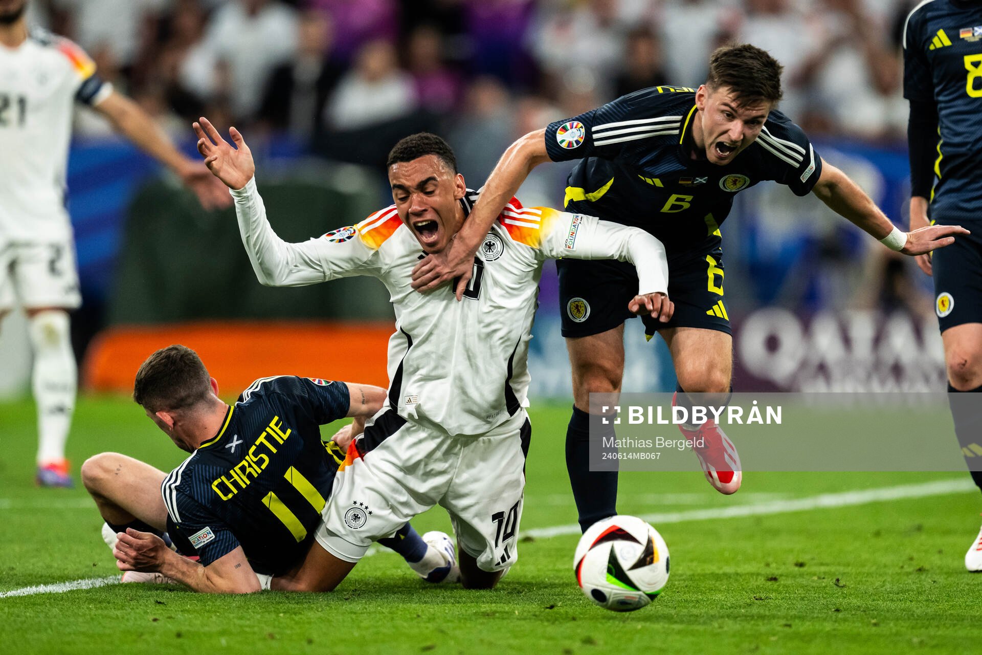 Ryan Christie and Kieran Tierney of Scotland against Jamal Musiala of Germany during the UEFA Euro 2024 Football Championship match between Germany and Scotland on June 14, 2024 in Munich.