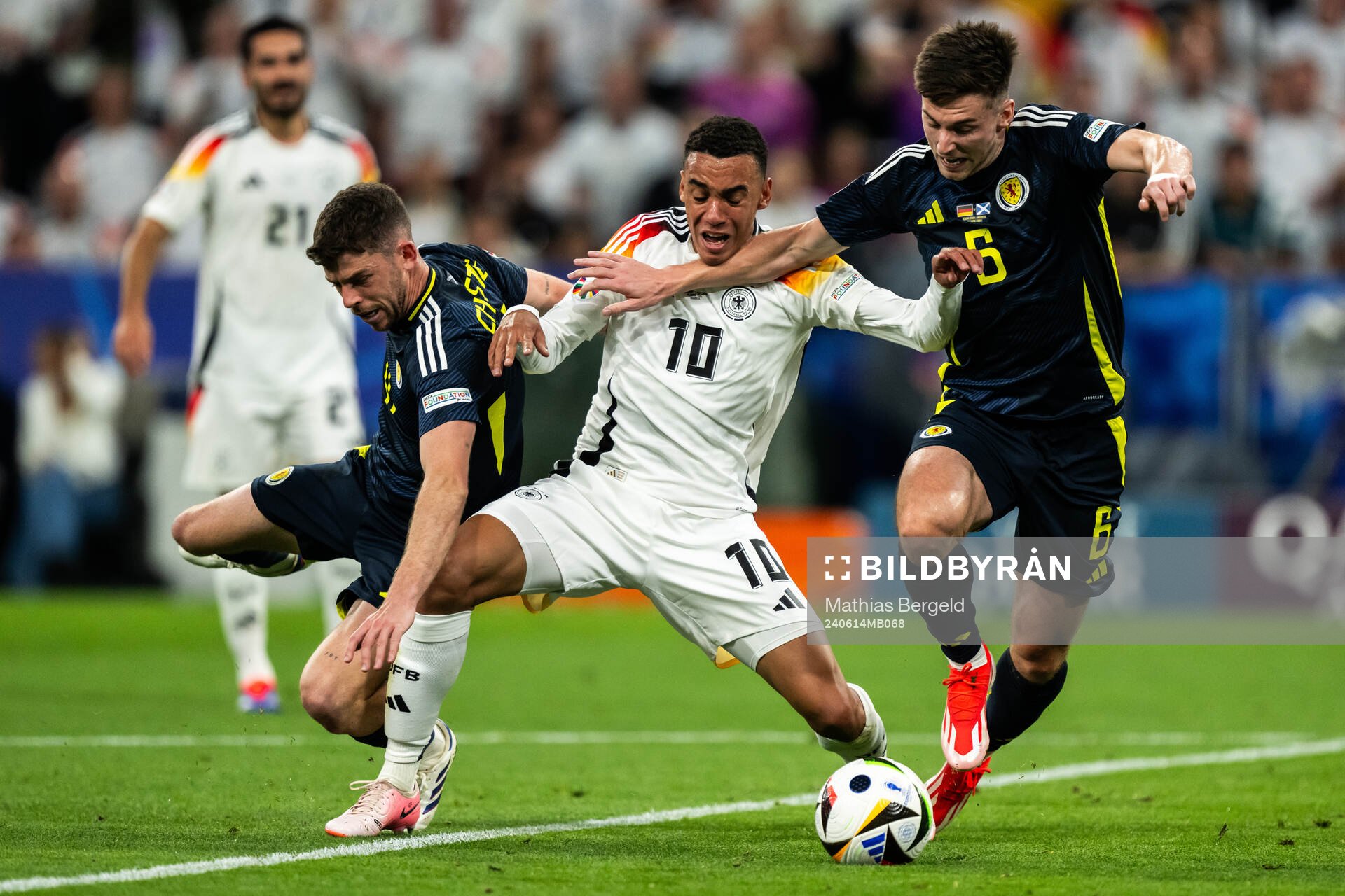 Ryan Christie and Kieran Tierney of Scotland against Jamal Musiala of Germany during the UEFA Euro 2024 Football Championship match between Germany and Scotland on June 14, 2024 in Munich.