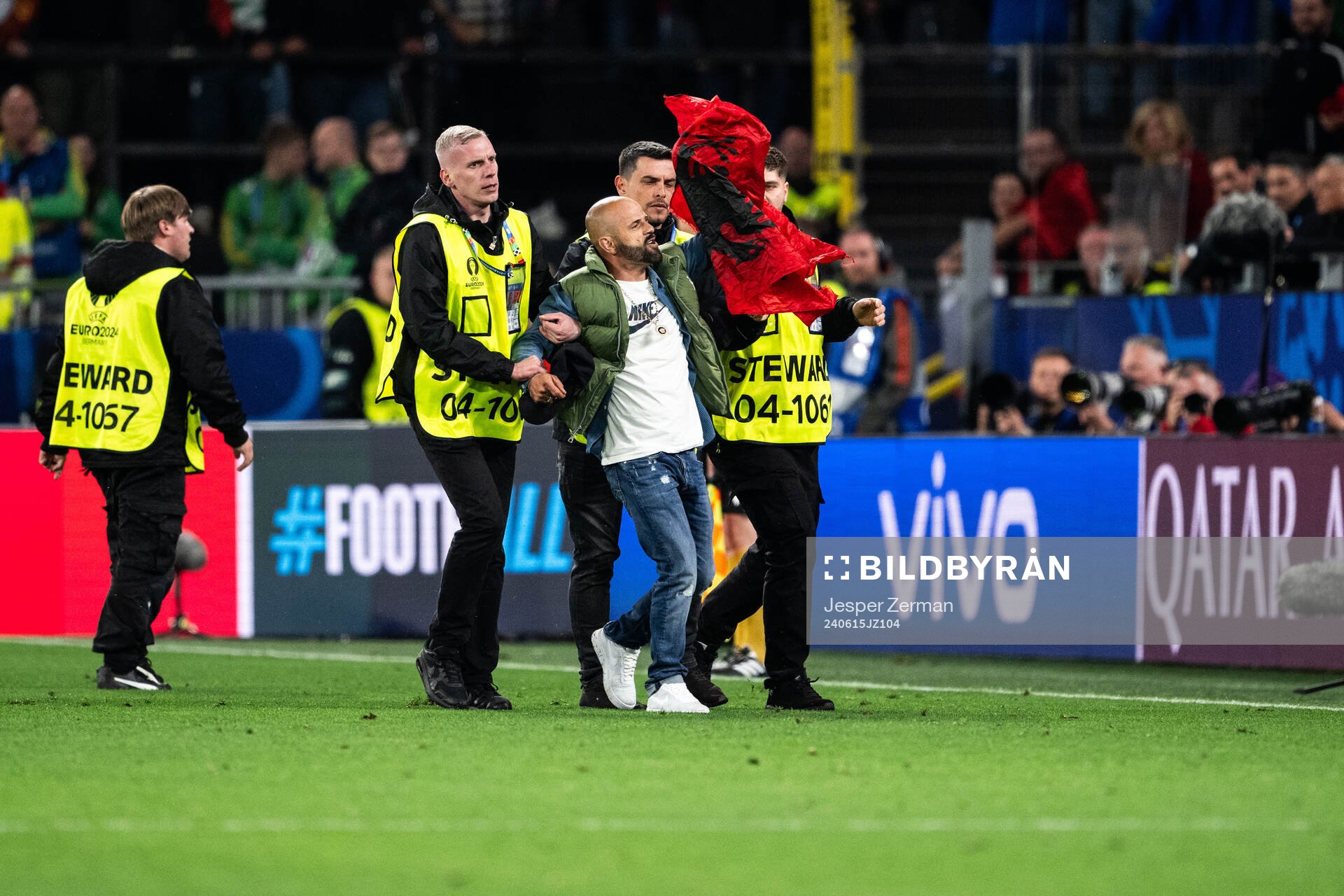 A pitch invader is escorted off the pitch