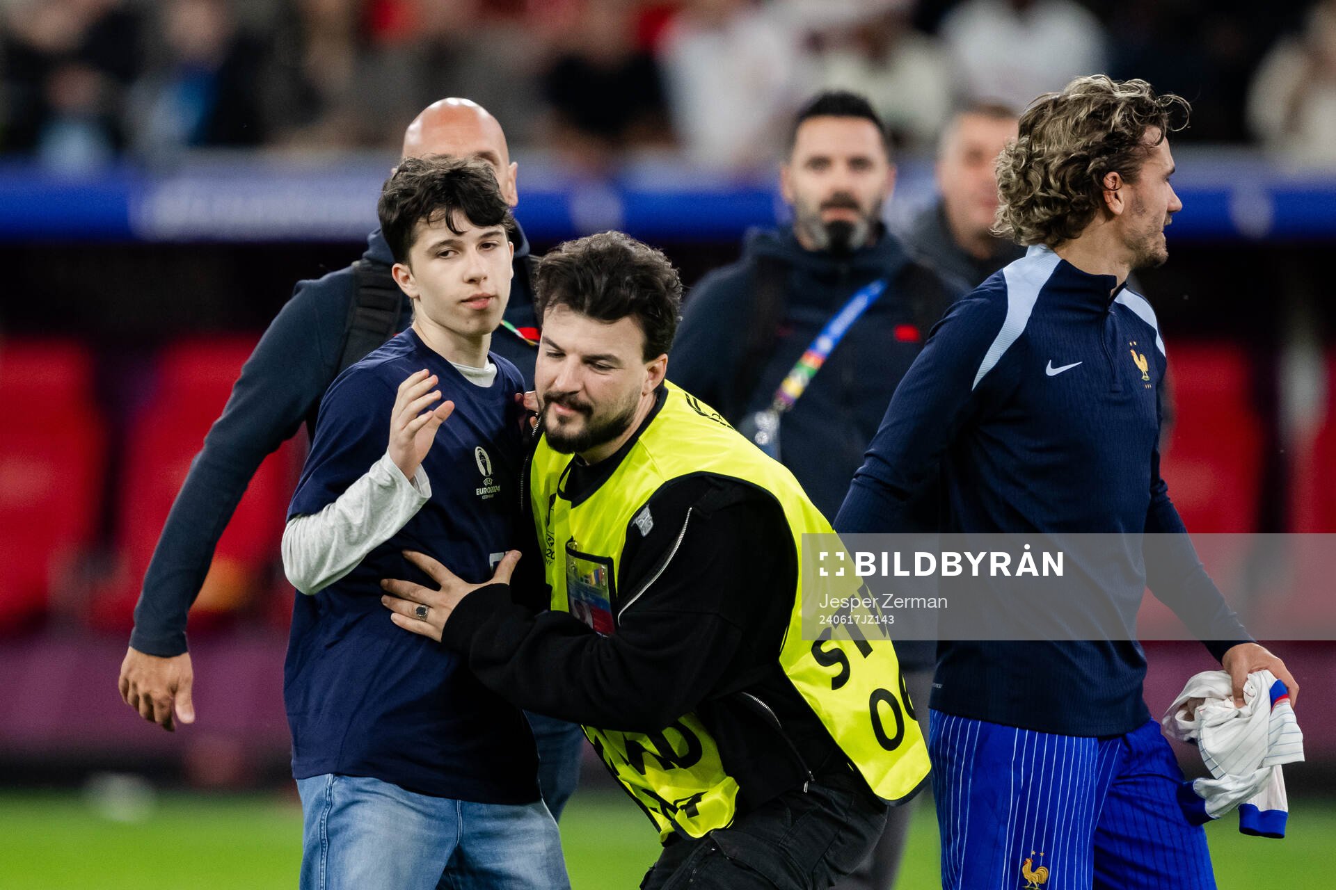 A pitch invader next to Antoine Griezmann of France