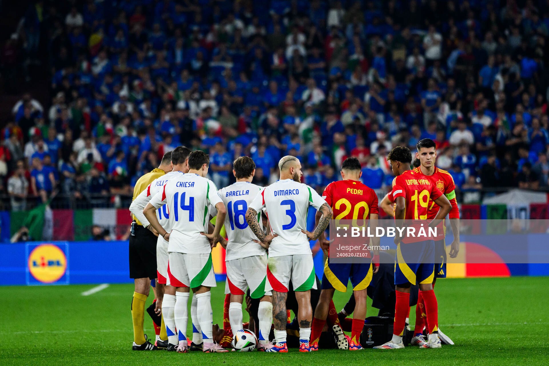Players of Italy and of Spain protect Rodrigo Hernandez in
