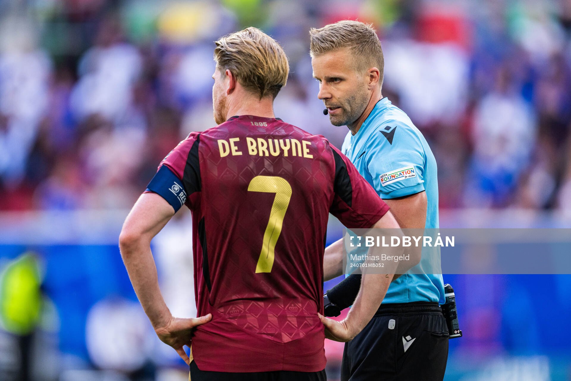Referee Glenn Nyberg and Kevin De Bruyne of Belgium