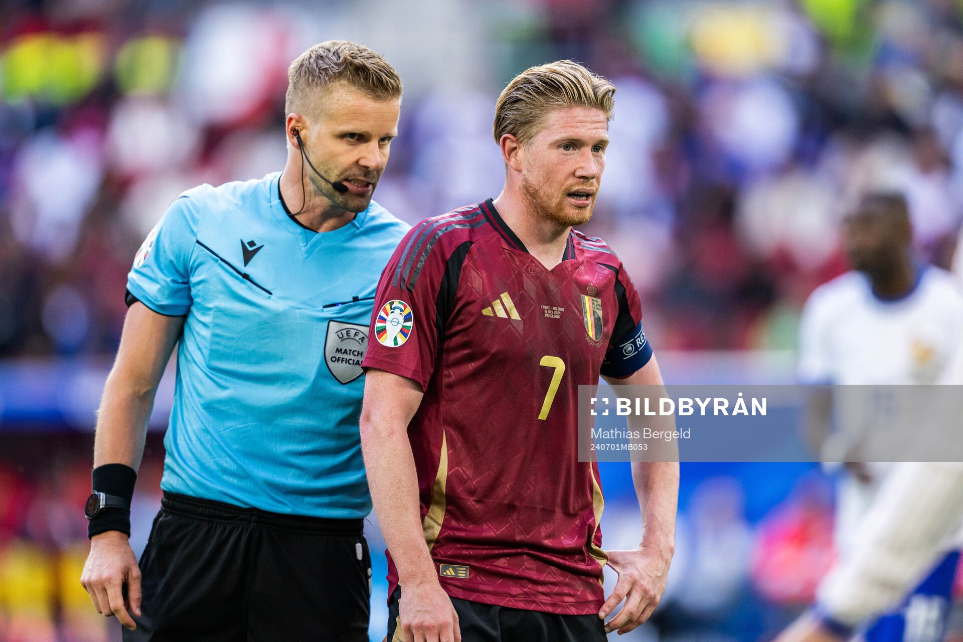 Referee Glenn Nyberg and Kevin De Bruyne of Belgium