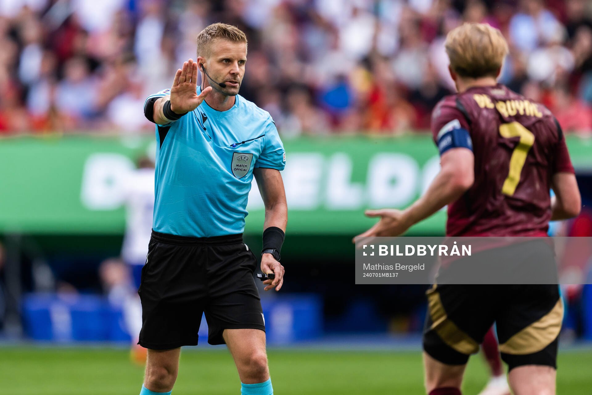 Referee Glenn Nyberg and Kevin De Bruyne of Belgium