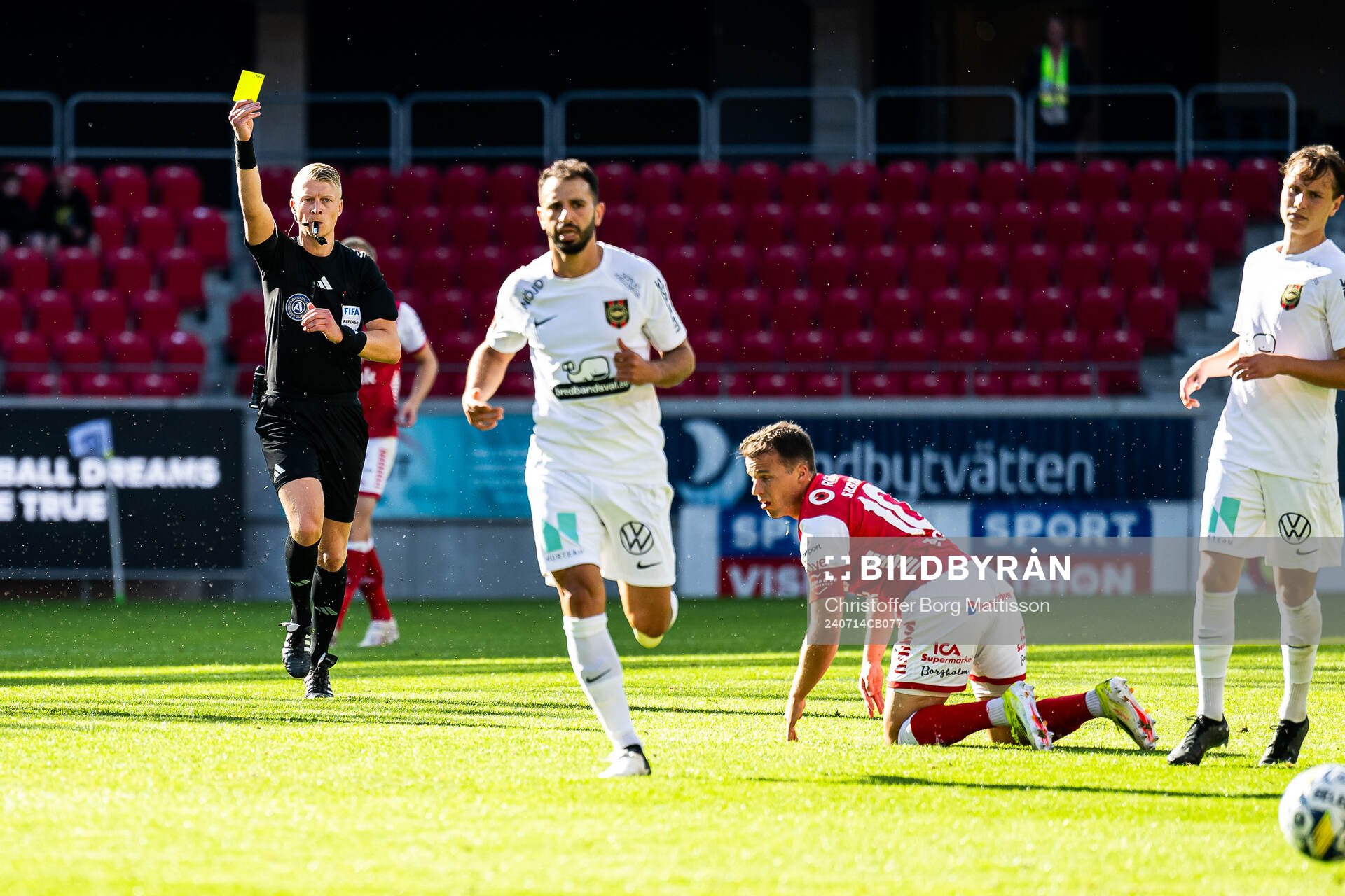 Domare Adam Ladebäck ger ett gult kort till