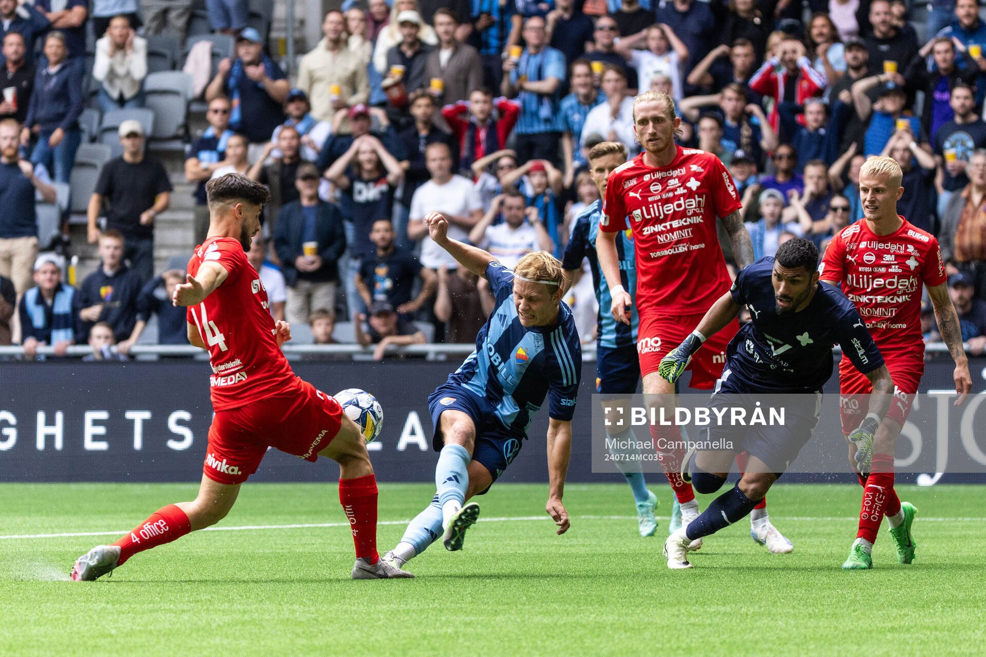 Djurgårdens Tobias Gulliksen mot Värnamos Gustav Engvall och målvakt Jonathan Ursin Rasheed under fotbollsmatchen i Allsvenskan mellan Djurgården och Värnamo den 14 juli 2024 i Stockholm.