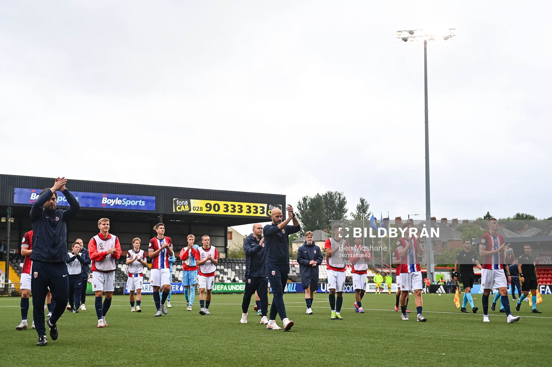 Norway players and staff applaud toward the travelling