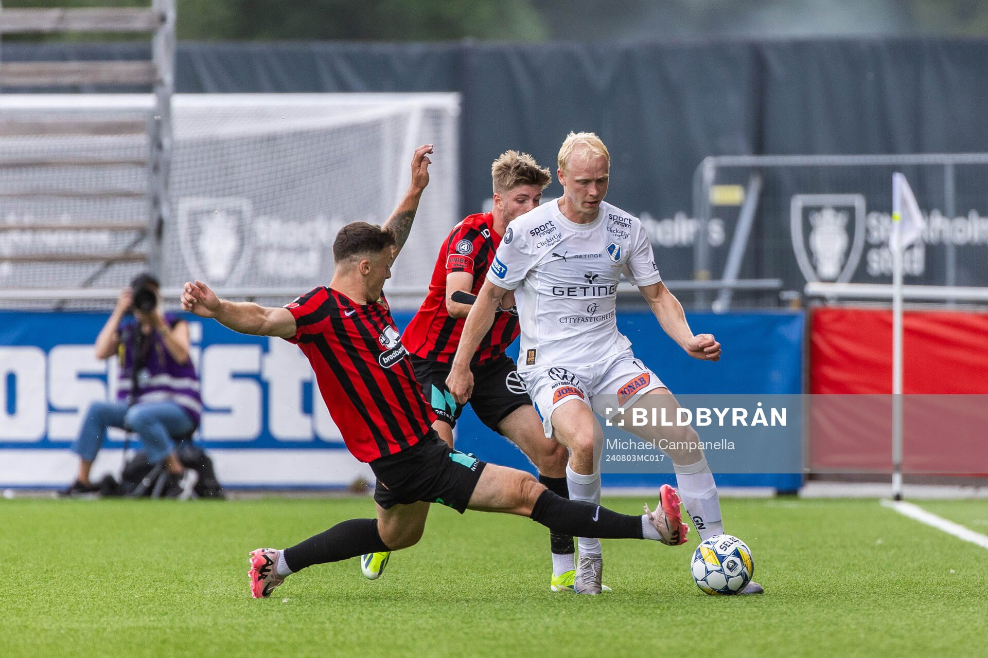 Brommapojkarnas Adam Skanning Jakobsen och Frederik Christensen i kamp om bollen med Halmstads André Boman under fotbollsmatchen i Allsvenskan mellan Brommapojkarna och Halmstad den 3 augusti 2024 i Stockholm.