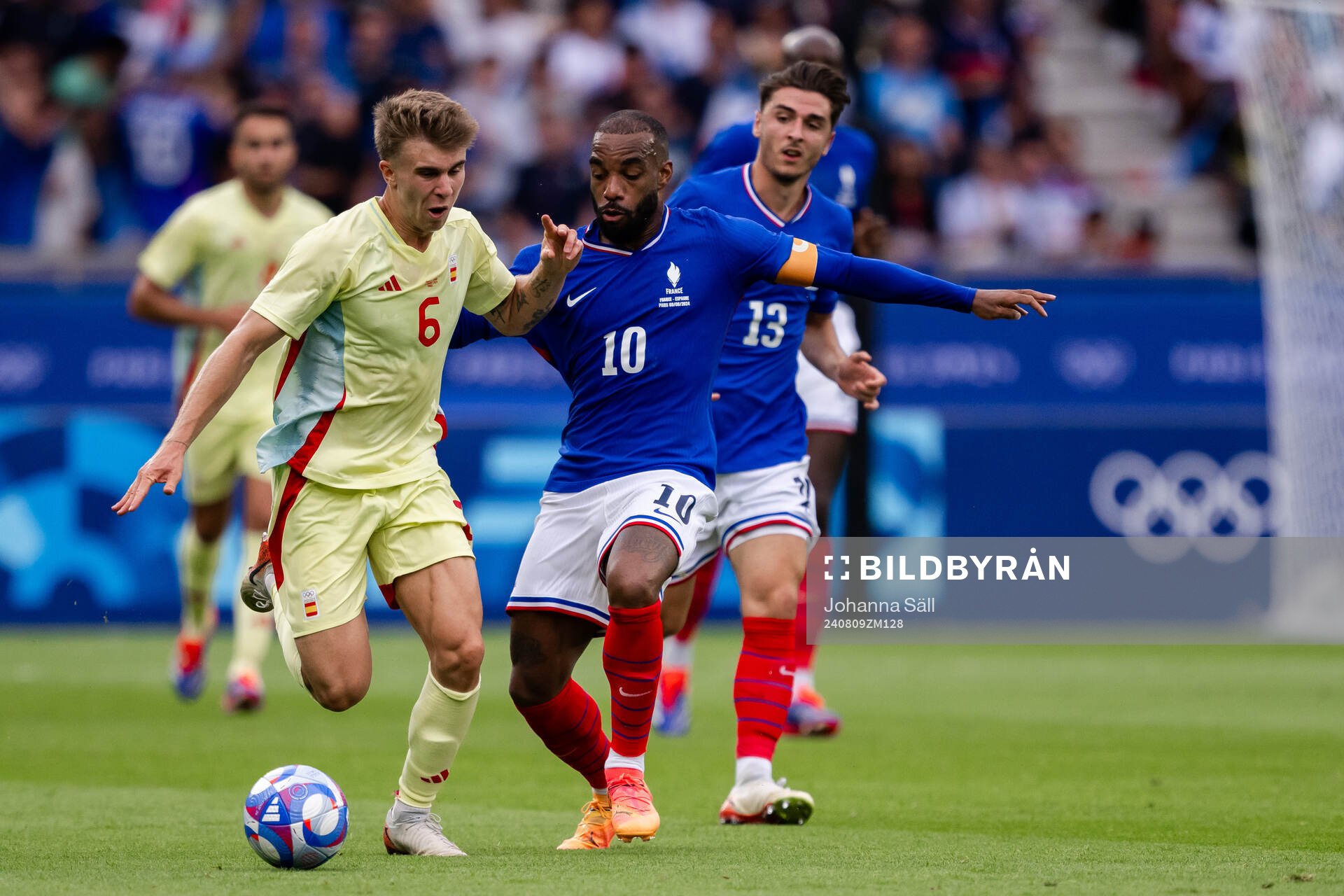 Pablo Barrios of Spain and Alexandre Lacazette of France in