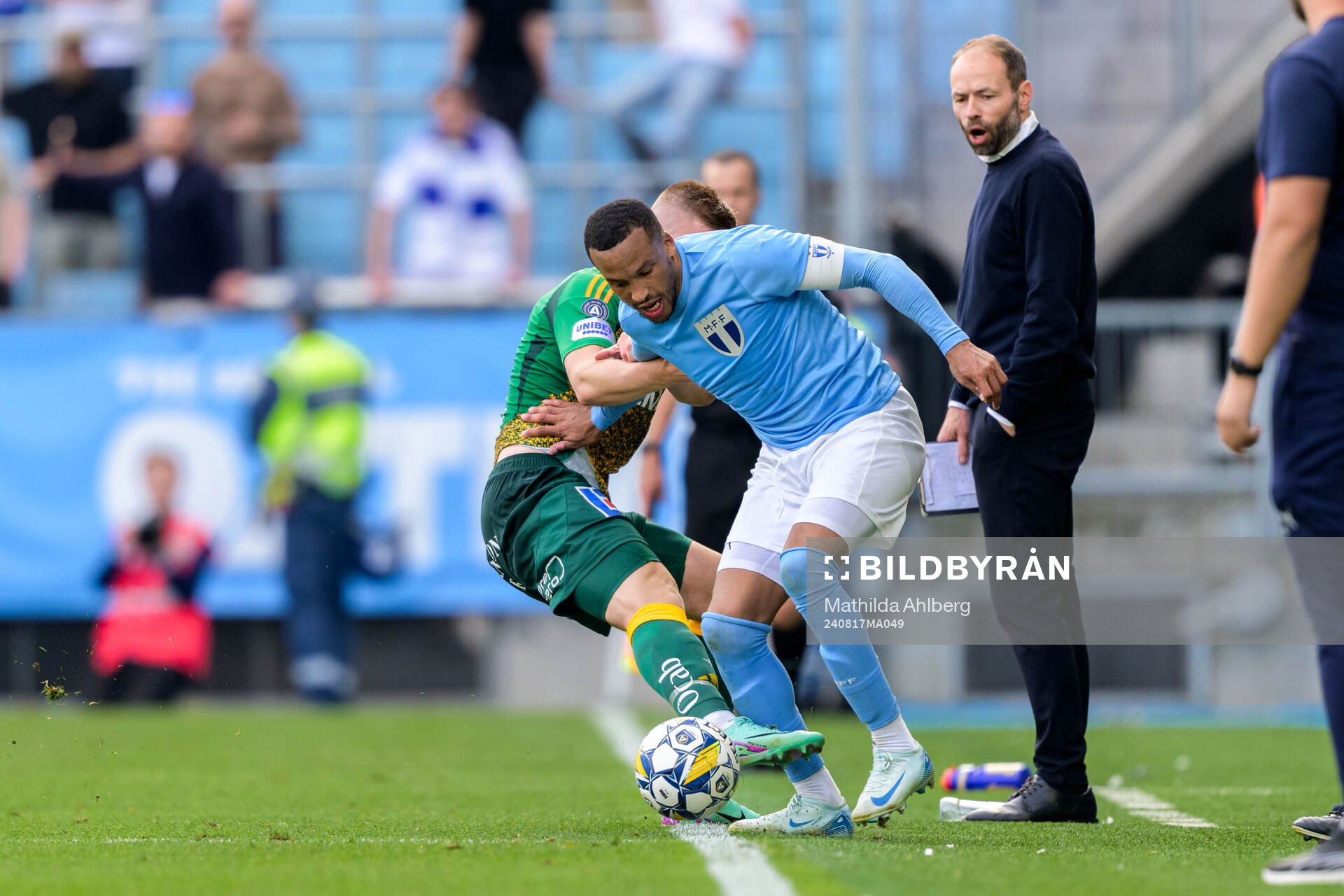 IFK Norrköpings Dino Salihovic och Malmö FFs Martin Olsson framför IFK Norrköpings tränare Andreas Alm under fotbollsmatchen i Allsvenskan mellan Malmö FF och IFK Norrköping den 17 augusti 2024 i Malmö.