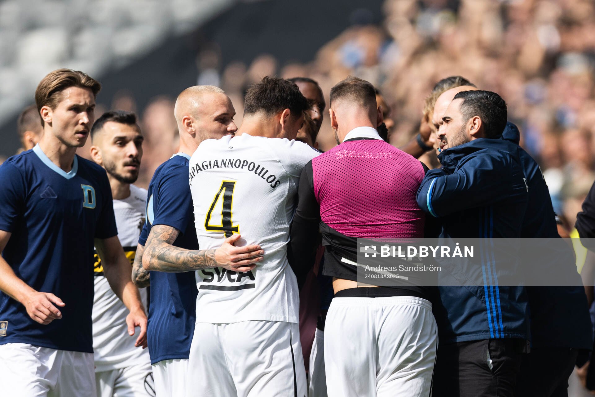 AIKs Sotirios Papagiannopoulos och Alexander Milosevic i diskussion med Djurgårdens Tokmac Nguen under fotbollsmatchen i Allsvenskan mellan Djurgården och AIK den 18 augusti 2024 i Stockholm.