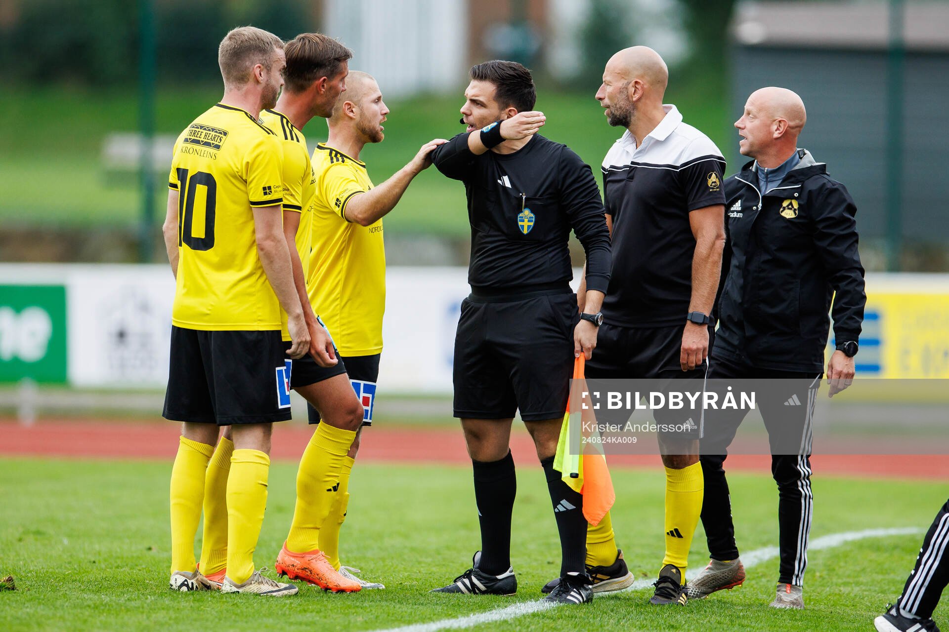 Astrios spelare och ledare i diskussion med assisterande domare under fotbollsmatchen i Div 2 Västra Götaland mellan Varbergs GIF och Astrio den 24 augusti 2024 i Varberg.