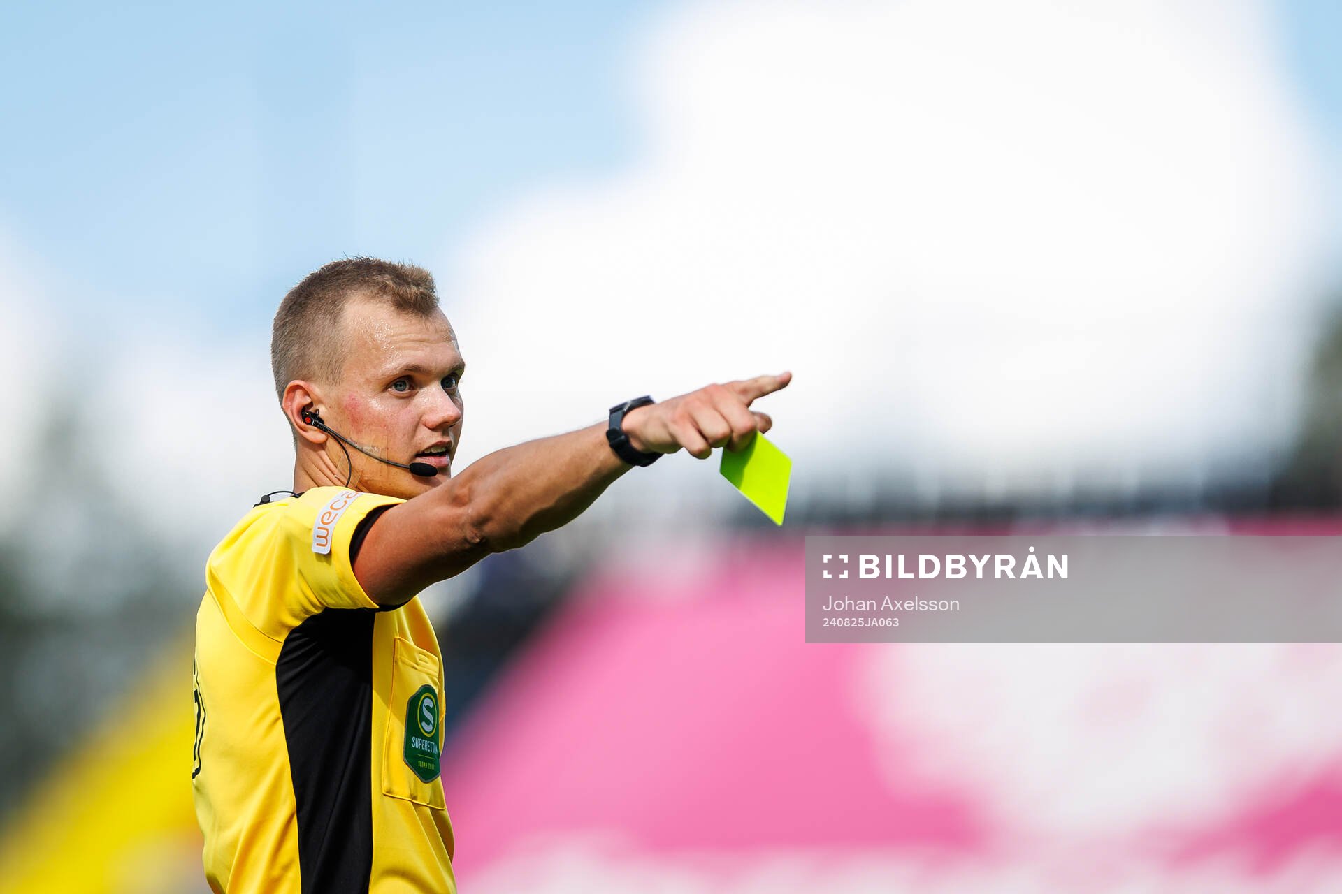 Domare Fredrik Alknäs visar gult kort till en av