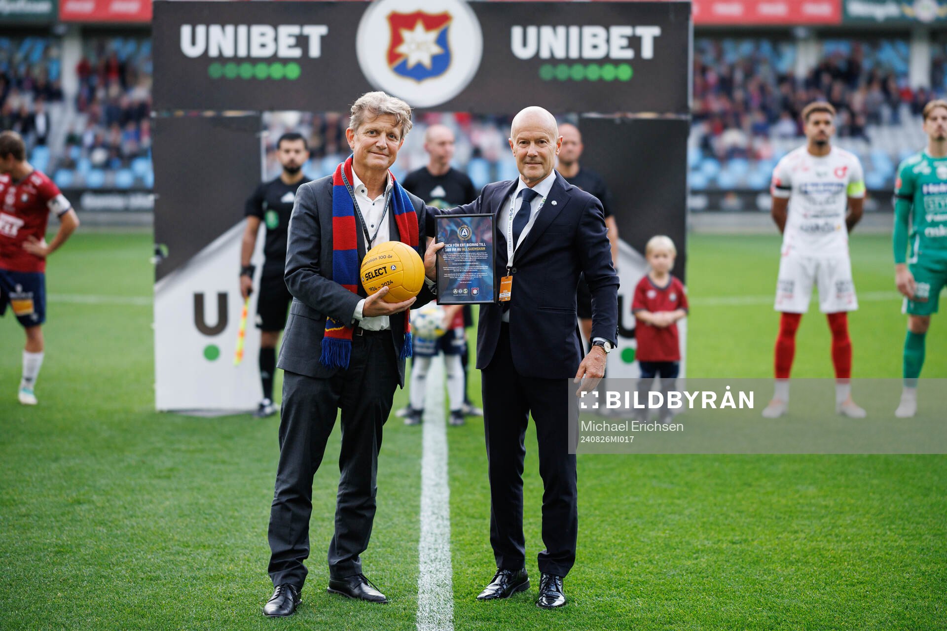 Örgrytes ordförande Terje Johansson tar emot en jubileumsboll av Petter Grundel, SEF, för att fira Allsvenskan 100 år inför inför fotbollsmatchen i Superettan mellan Örgryte och Degerfors den 26 augusti 2024 i Göteborg.
