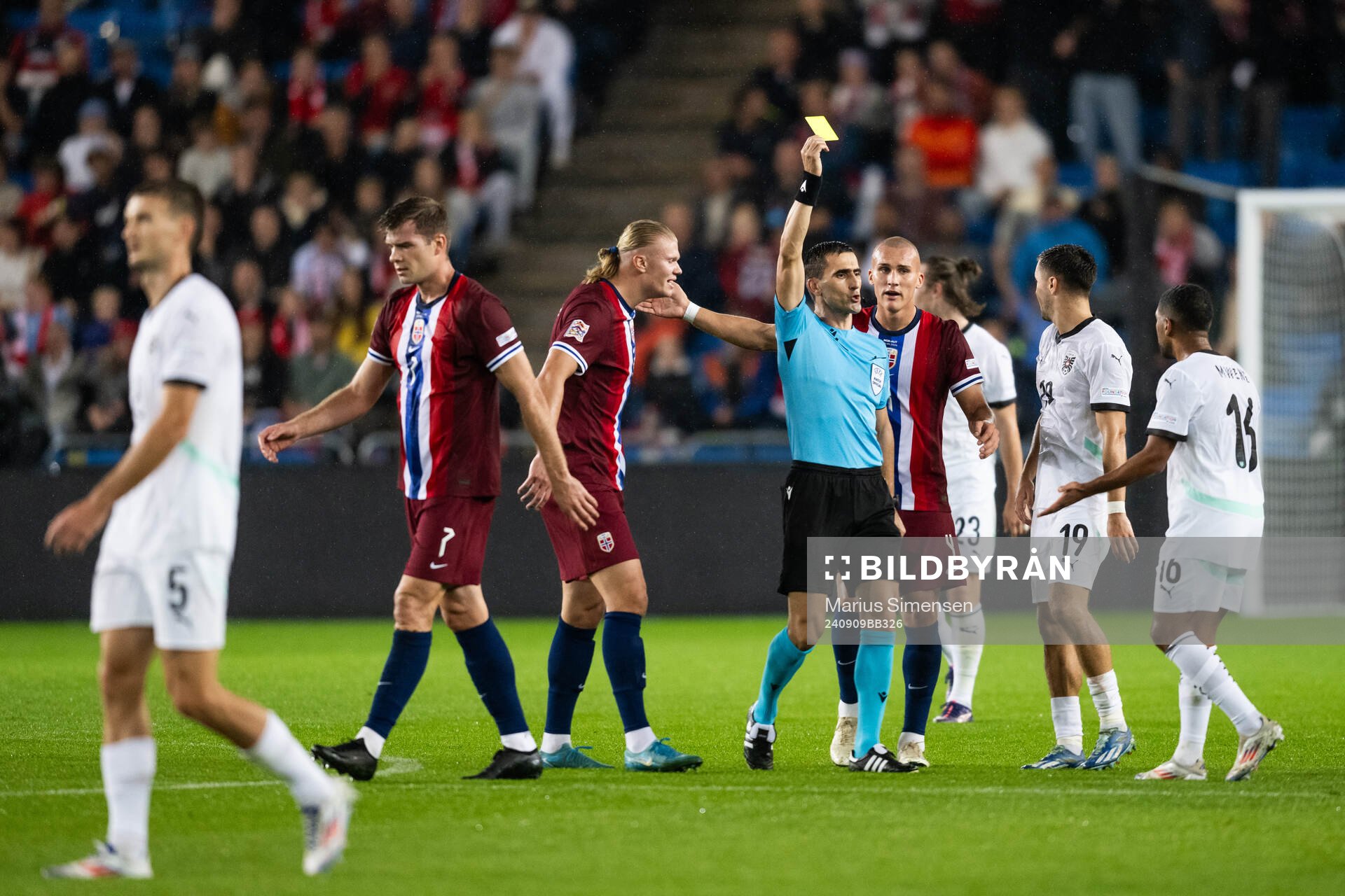 Referee Vladan Todorovic gives a yellow card to Phillipp