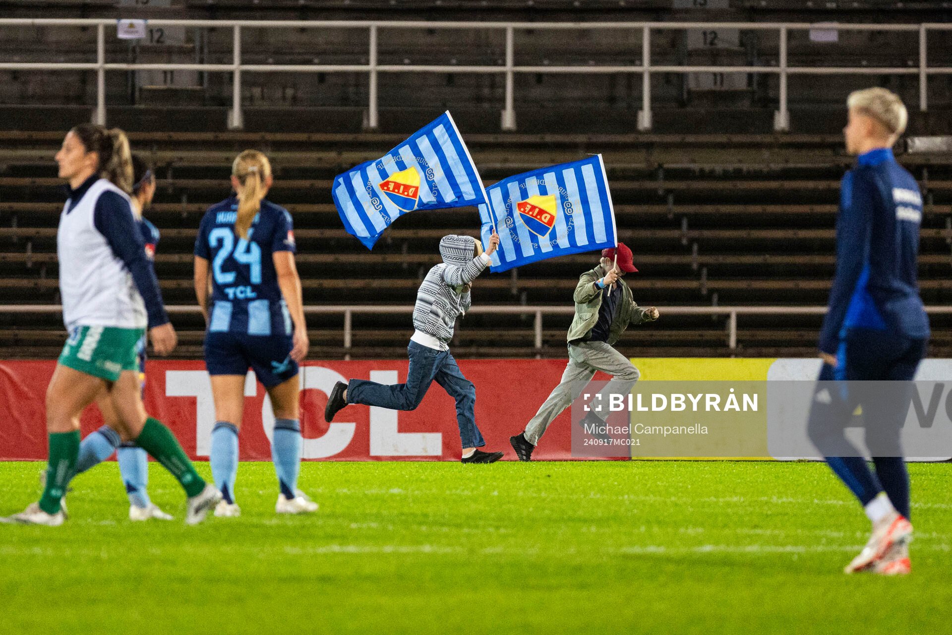 Unga Djurgårdens supportrar med flaggor storma planen