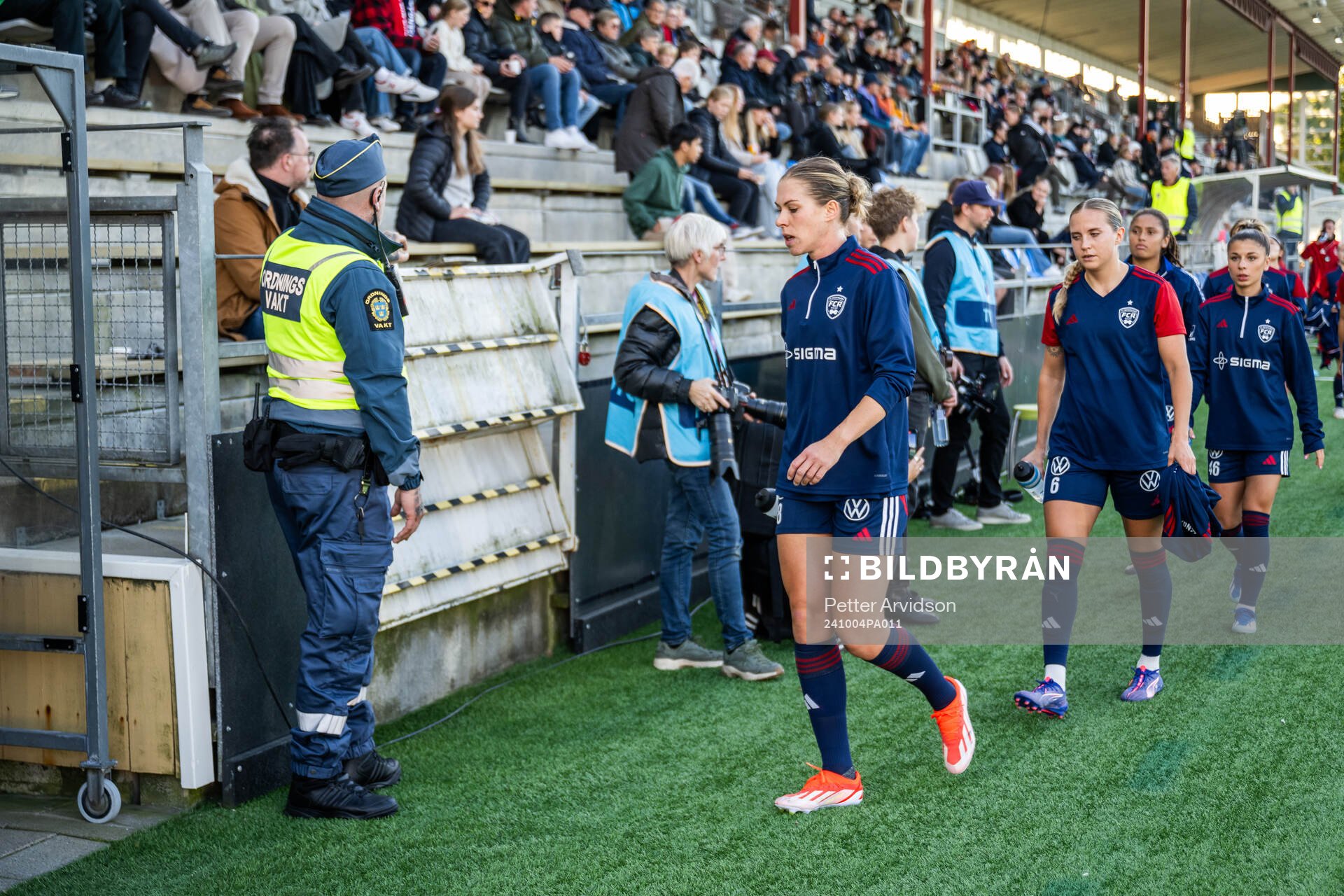 Ordningsvakt vid sidan av planen när FC Rosengårds Rebecca Knaak går förbi inför fotbollsmatchen i Damallsvenskan mellan FC Rosengård och Kristianstad den 4 oktober 2024 i Malmö.