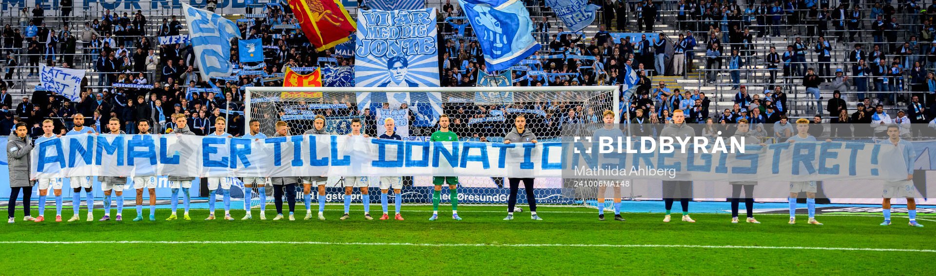 Spelare med banderoll framför klacken