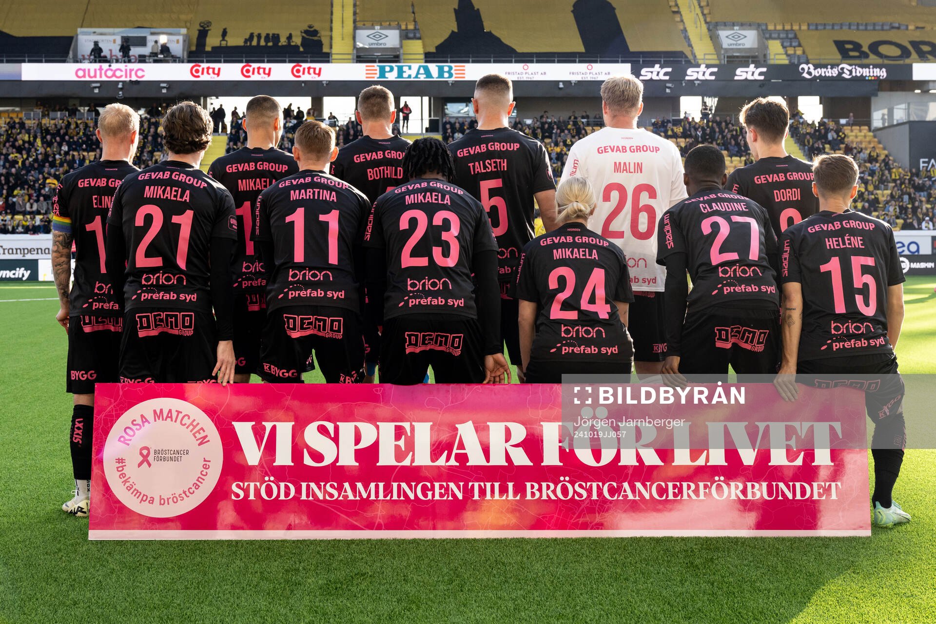 spelare ställer upp på gruppbild med rygg mot kameran