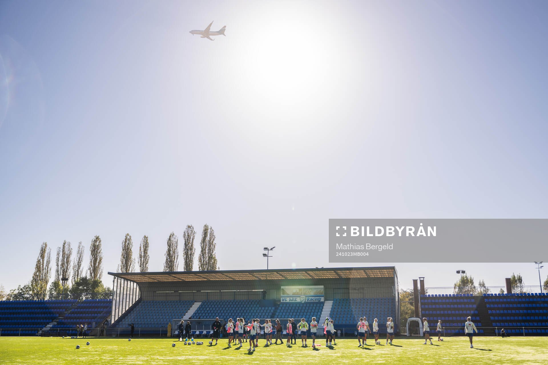 An airplane passes over players of the Swedish women's