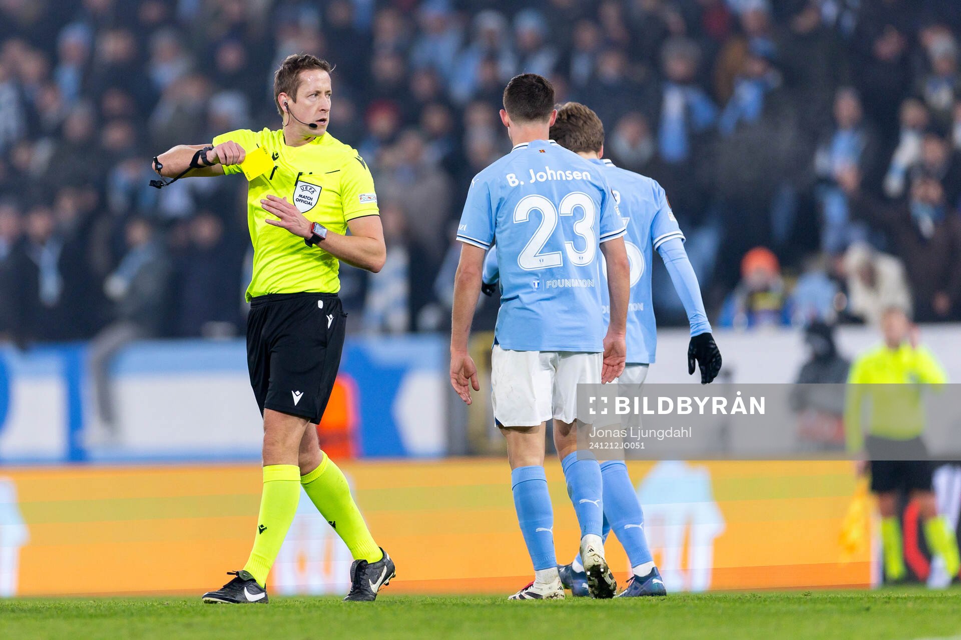 Referee John Brooks with a yellow card