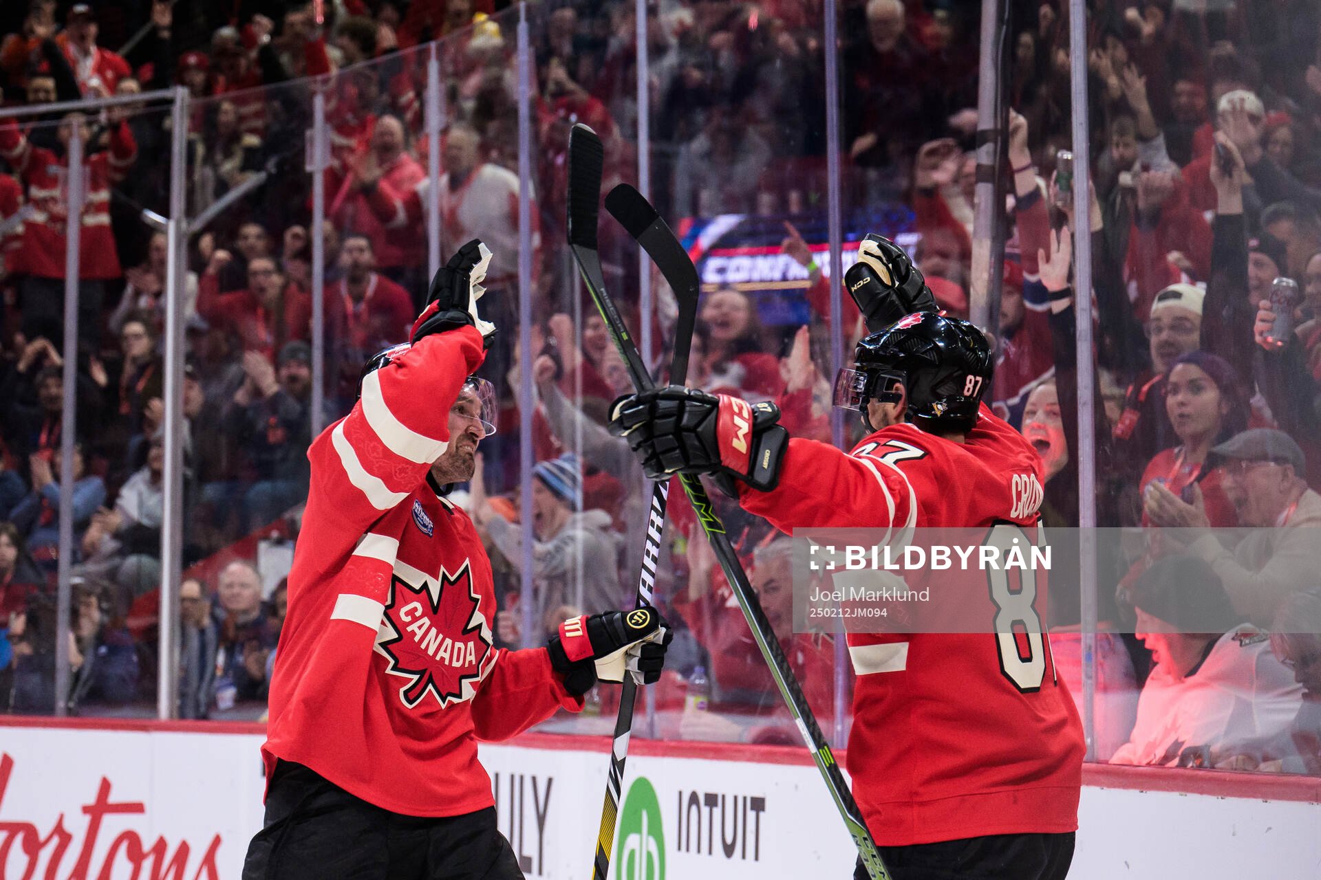 Mark Stone and Sidney Crosby of Canada celebrate the 3-1