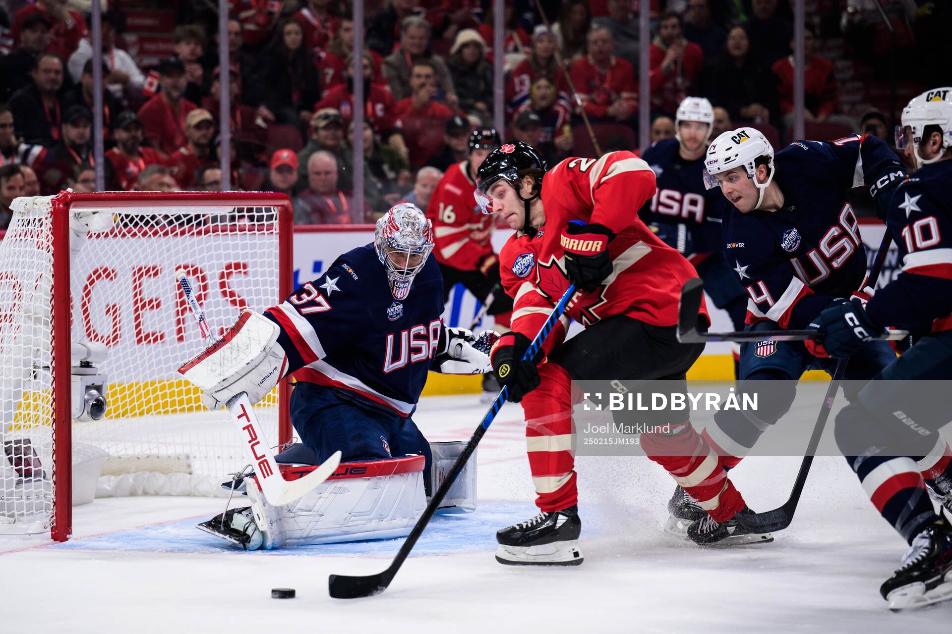Goaltender Connor Hellebuyck of USA is being challenged by