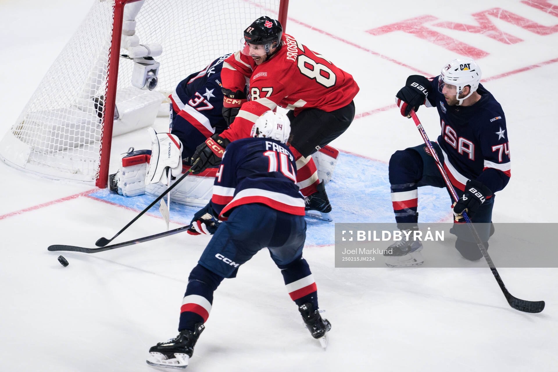 Sidney Crosby of Canada challenges Brock Faber, goaltender