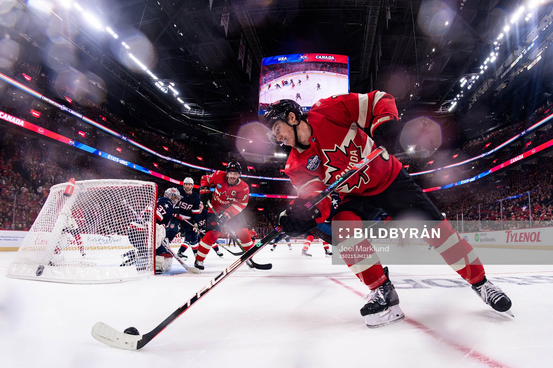 Goaltender Connor Hellebuyck of USA is being challenged by