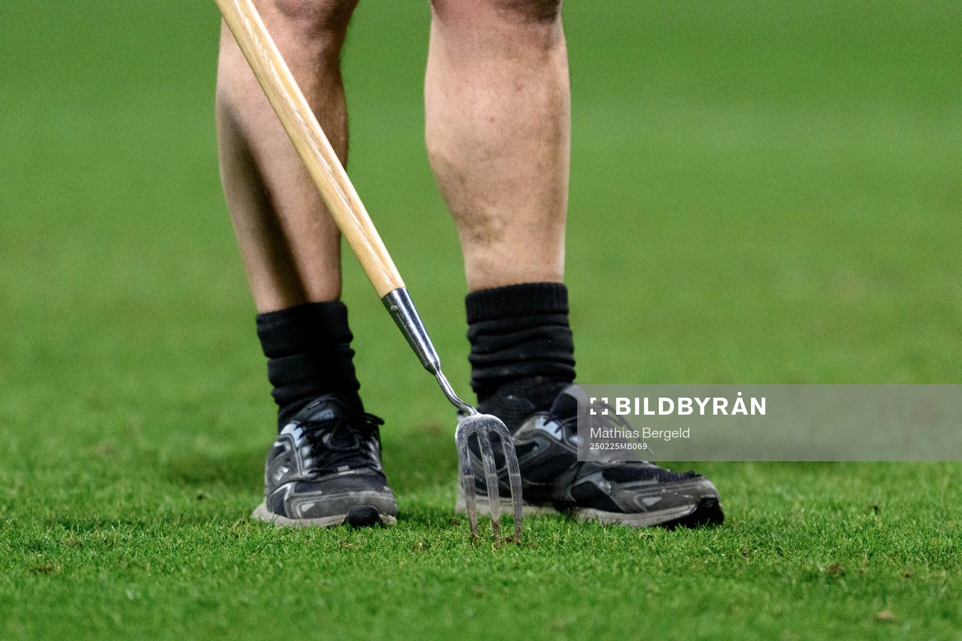A steward repairs the pitch at halftime