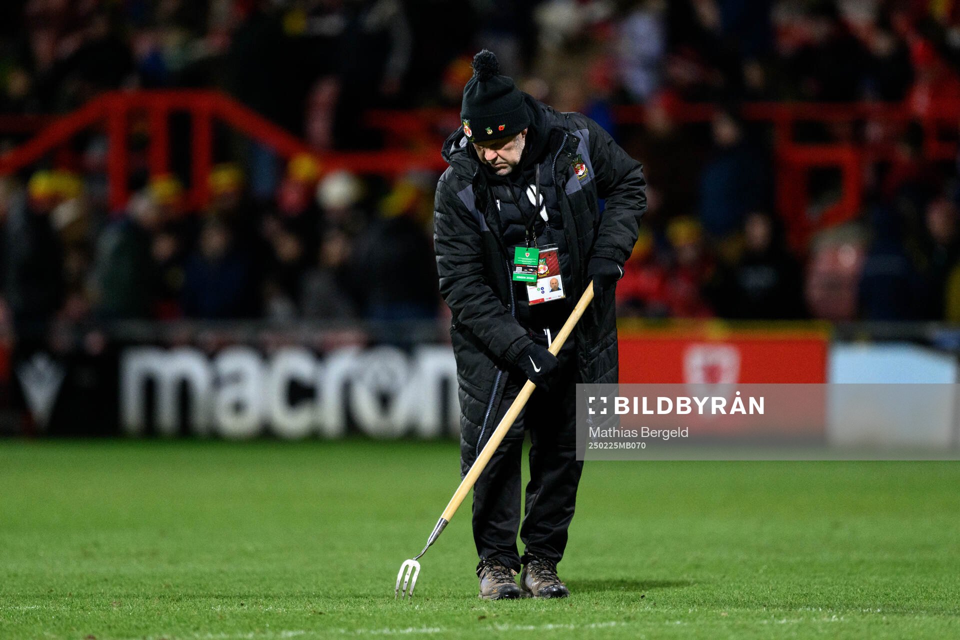 A steward repairs the pitch at halftime
