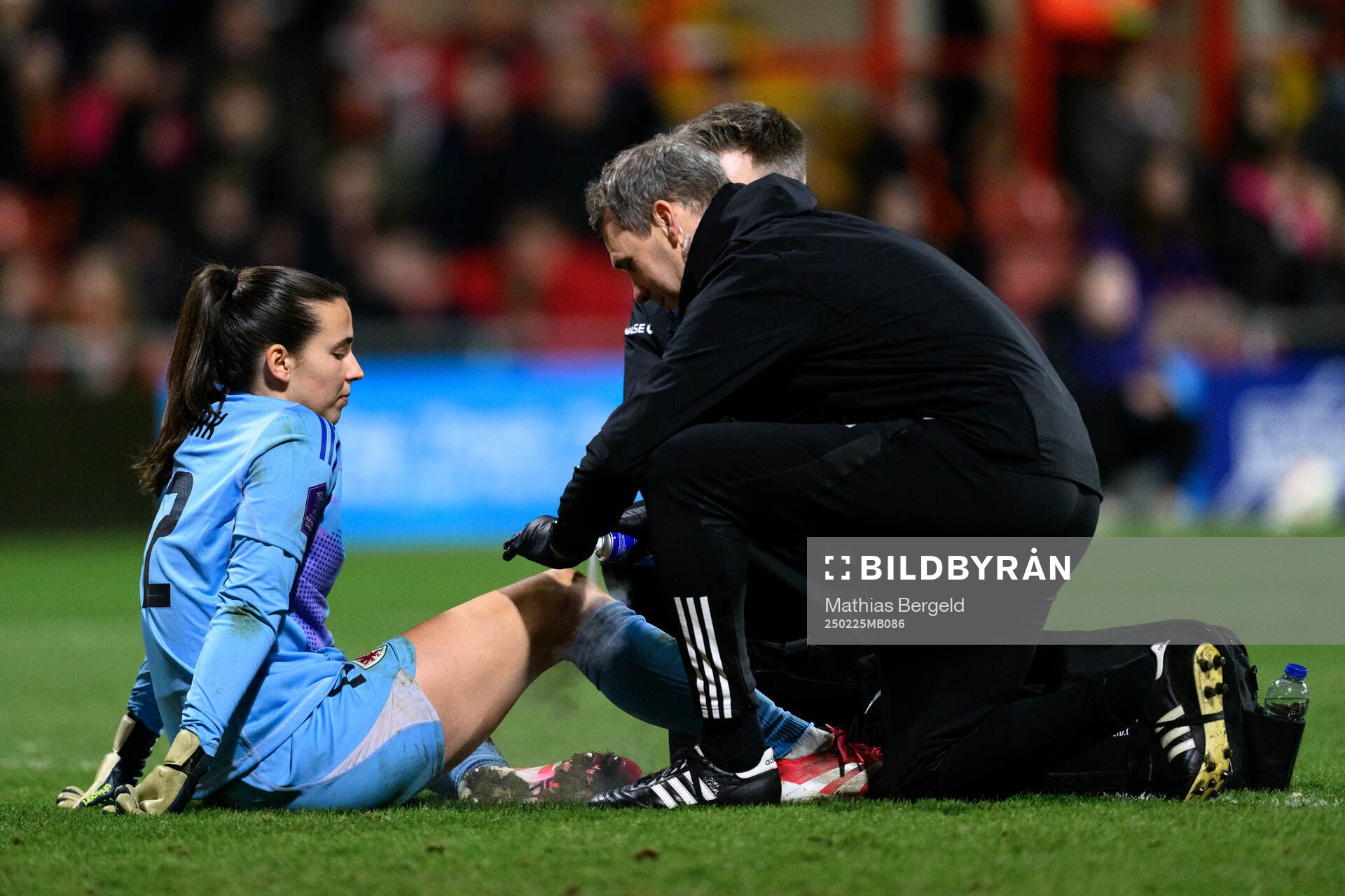 Goalkeeper Olivia Clark of Wales receives medical attention
