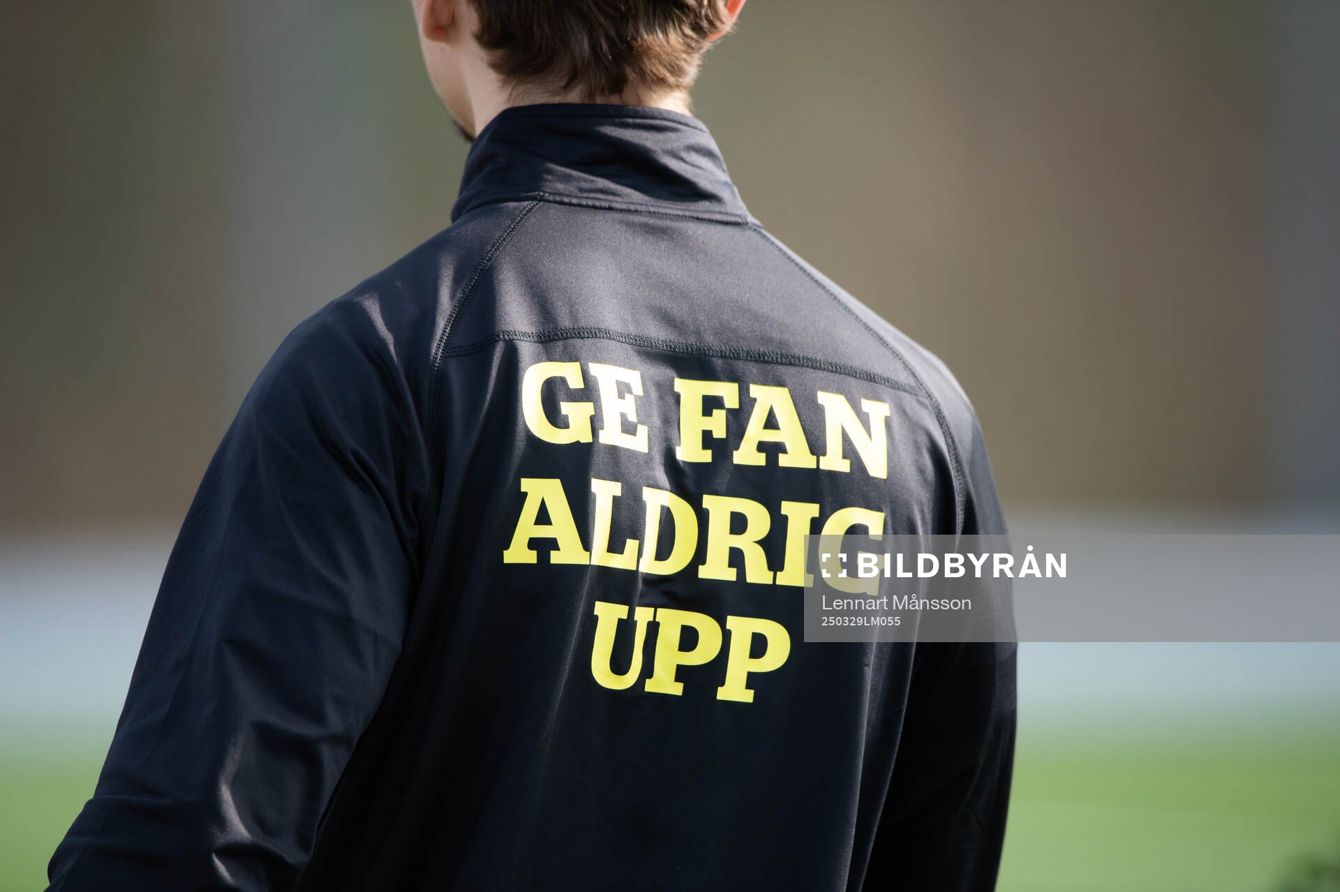Budskapet ”Ge fan aldrig upp” på ryggen i matchen mellan IFK Hässleholm U19 och Perslövs AIF i Hässleholm 29 mars 2025.
