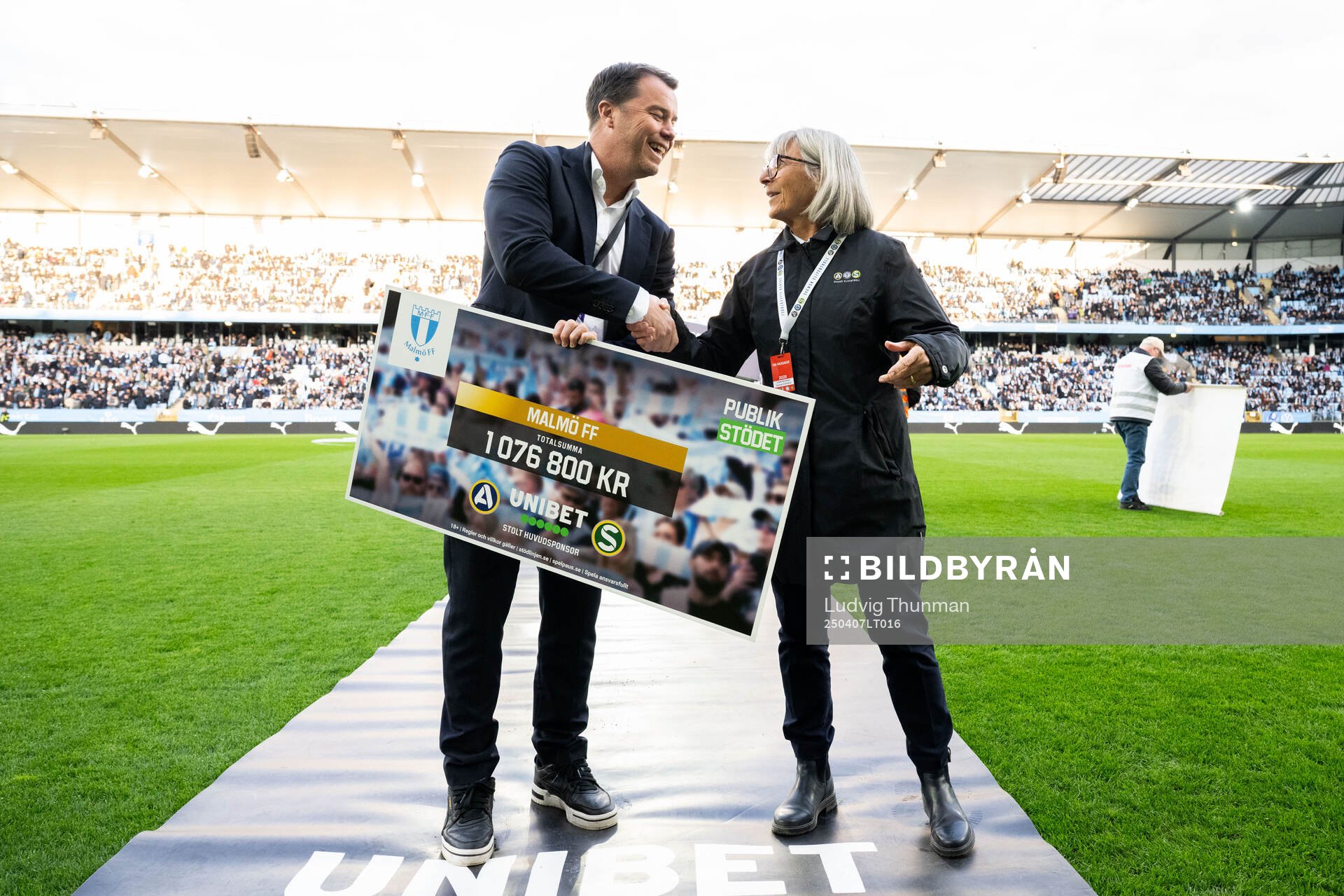 Malmö FFs sportchef Daniel Andersson tar emot en check