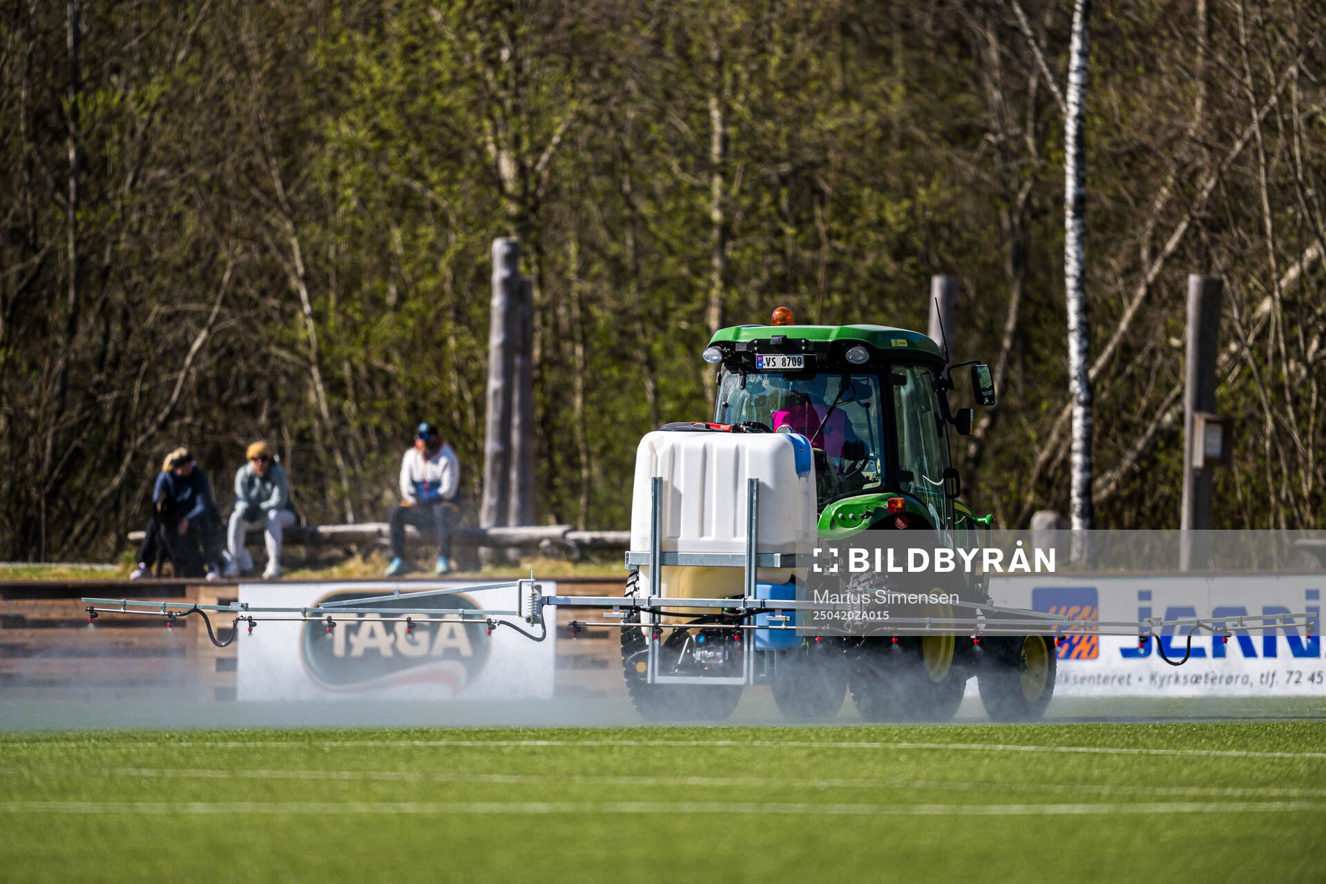 A tractor waters the pitch at half-time break