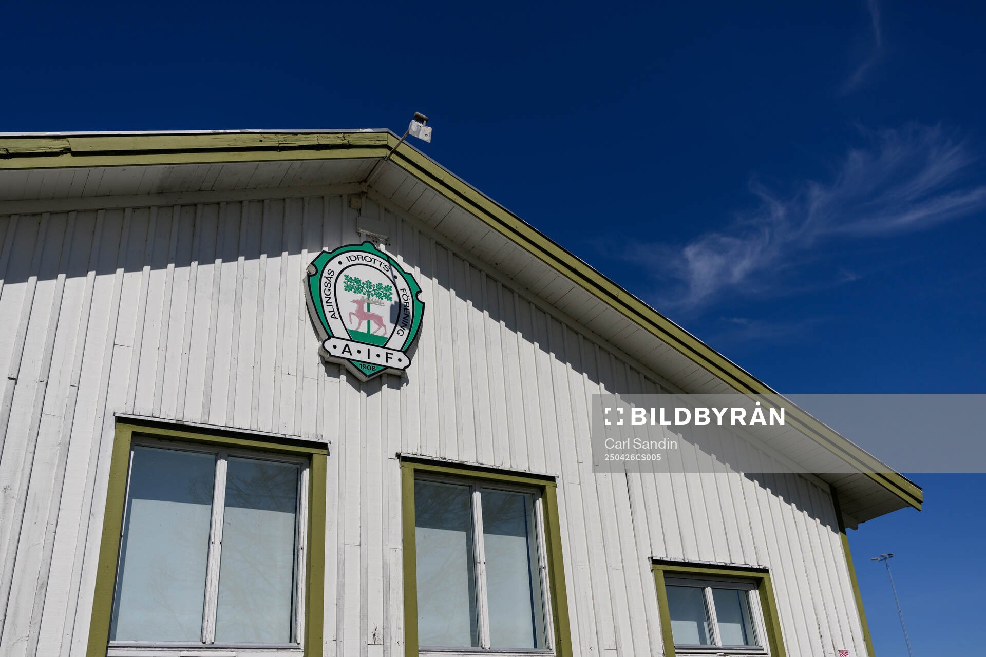 Alingsås idrottsförenings klubbhus med klubbmärke