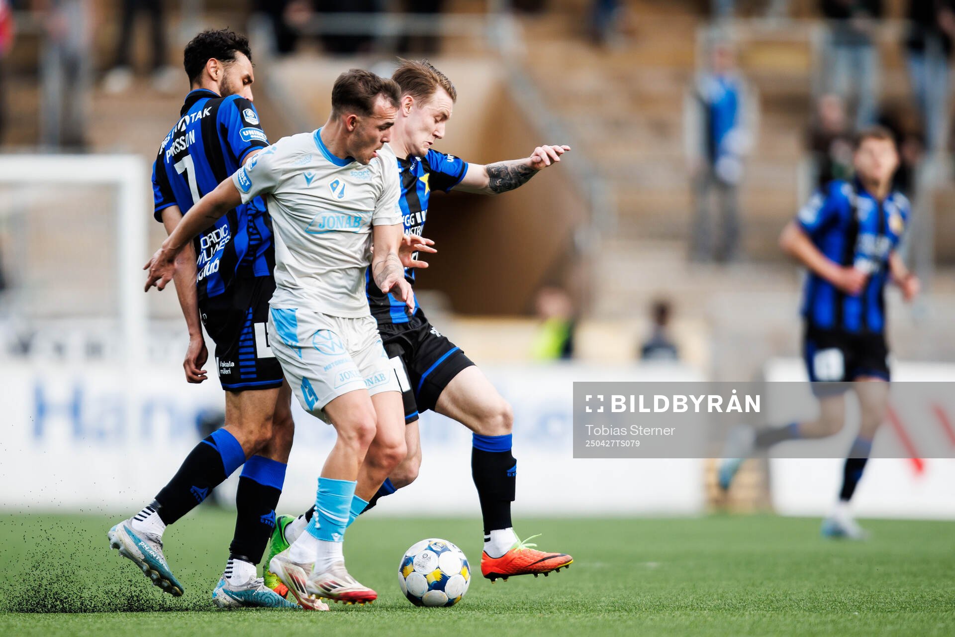 Sirius Joakim Persson och Noel Milleskog mot Halmstads Aleksander Damnjanovic Nilsson under fotbollsmatchen i Allsvenskan mellan Sirius och Halmstad den 27 april 2025 i Uppsala.