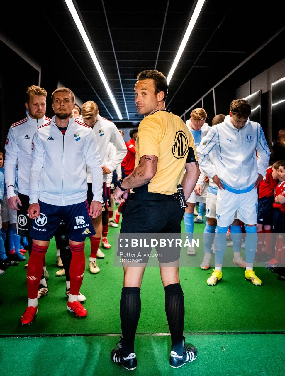 Fotbollsdomaren Kristoffer Karlsson i spelargången inför att lagen ska göra entre, till vänster Östers Ivan Kricak och till höger Malmö FFs Colin Rösler inför fotbollsmatchen i Allsvenskan mellan Malmö FF och Öster den 29 april 2025 i Malmö. 