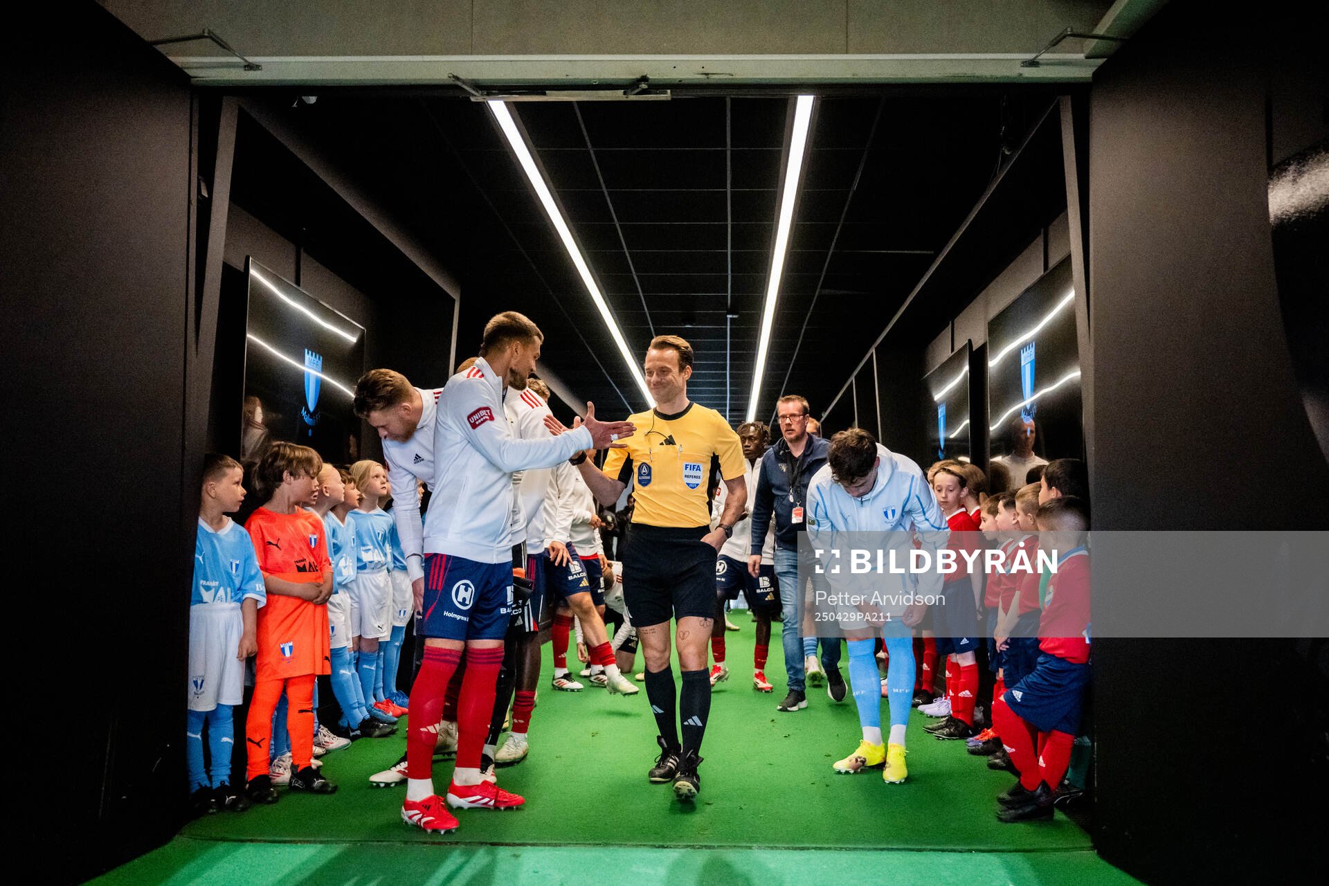 Fotbollsdomaren Kristoffer Karlsson hälsar på Östers Ivan Kricak och till höger står Malmö FFs Colin Rösler i spelargången inför fotbollsmatchen i Allsvenskan mellan Malmö FF och Öster den 29 april 2025 i Malmö.