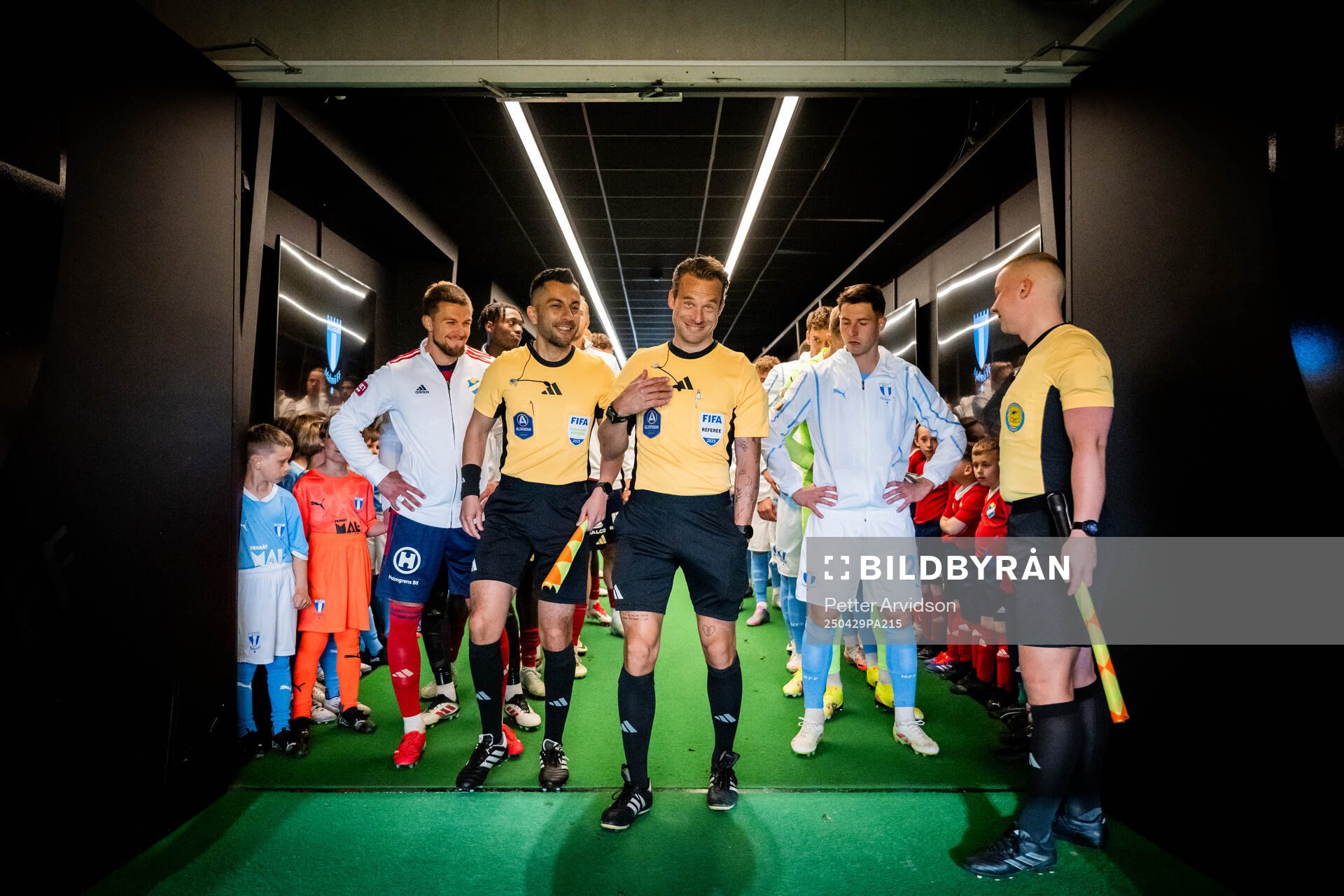 Fotbollsdomaren Kristoffer Karlsson i spelargången inför att lagen ska göra entre, till vänster linjedomare Mahbod Beigi och till höger linjedomare Anton Sjöberg, och till vänster står Östers Ivan Kricak och till höger Malmö FFs Lasse Berg Johnsen inför fotbollsmatchen i Allsvenskan mellan Malmö FF och Öster den 29 april 2025 i Malmö.