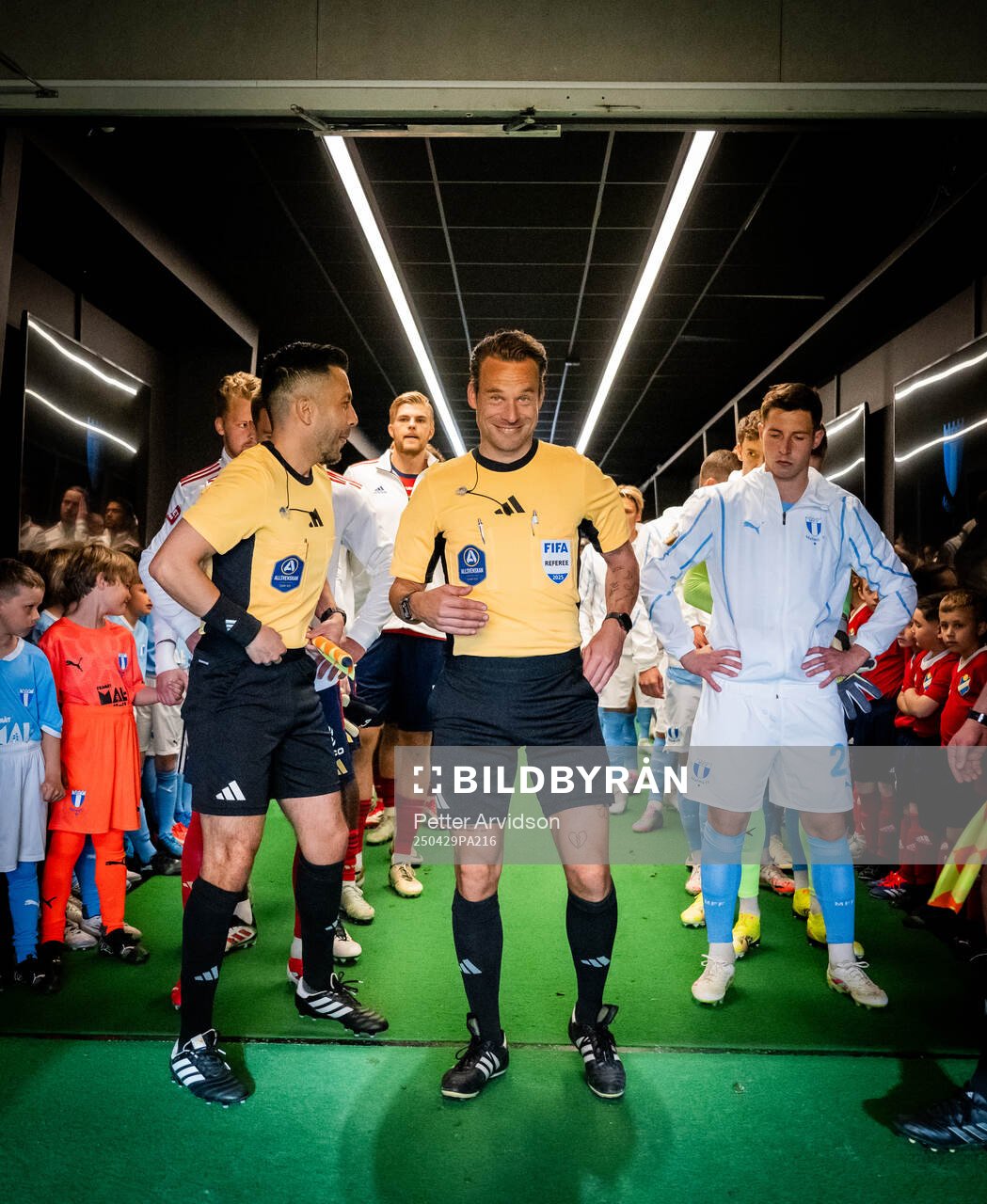 Fotbollsdomaren Kristoffer Karlsson i spelargången inför att lagen ska göra entre, till vänster linjedomare Mahbod Beigi och till höger Malmö FFs Lasse Berg Johnsen inför fotbollsmatchen i Allsvenskan mellan Malmö FF och Öster den 29 april 2025 i Malmö.
