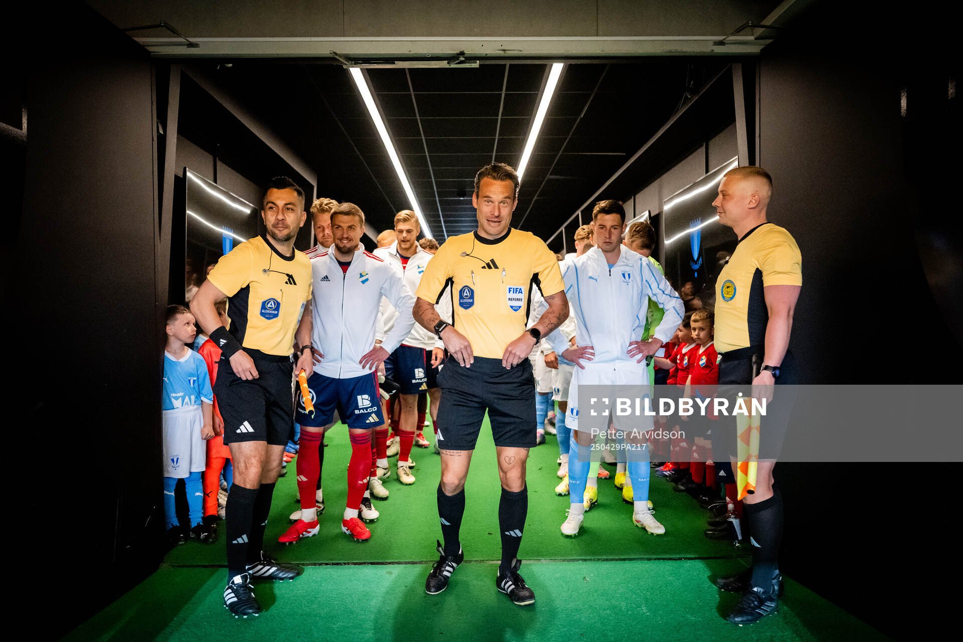 Fotbollsdomaren Kristoffer Karlsson i spelargången inför att lagen ska göra entre, till vänster linjedomare Mahbod Beigi och till höger linjedomare Anton Sjöberg, och till vänster står Östers Ivan Kricak och till höger Malmö FFs Lasse Berg Johnsen inför fotbollsmatchen i Allsvenskan mellan Malmö FF och Öster den 29 april 2025 i Malmö.