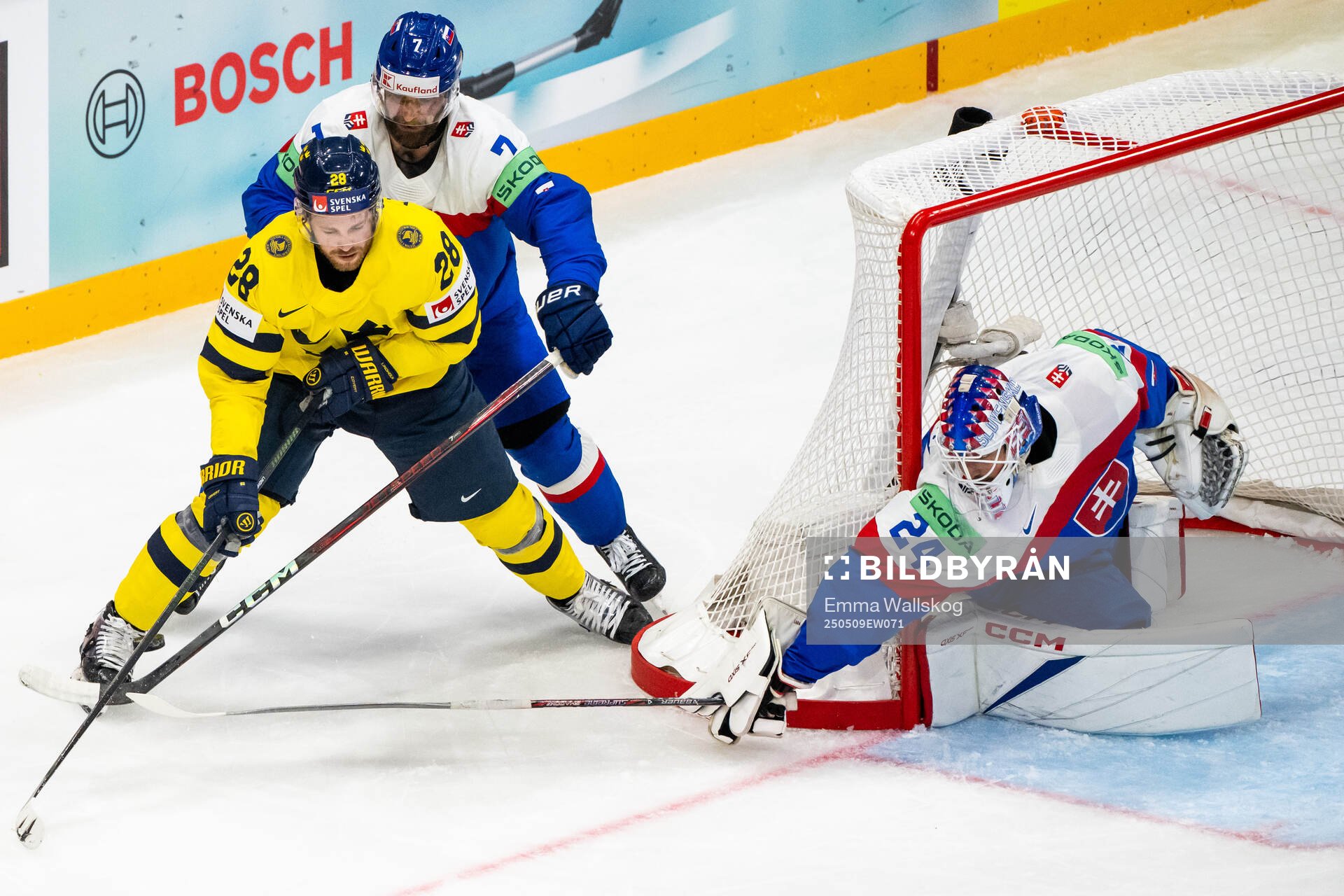 Elias Lindholm of Sweden competes for the puck with Mario
