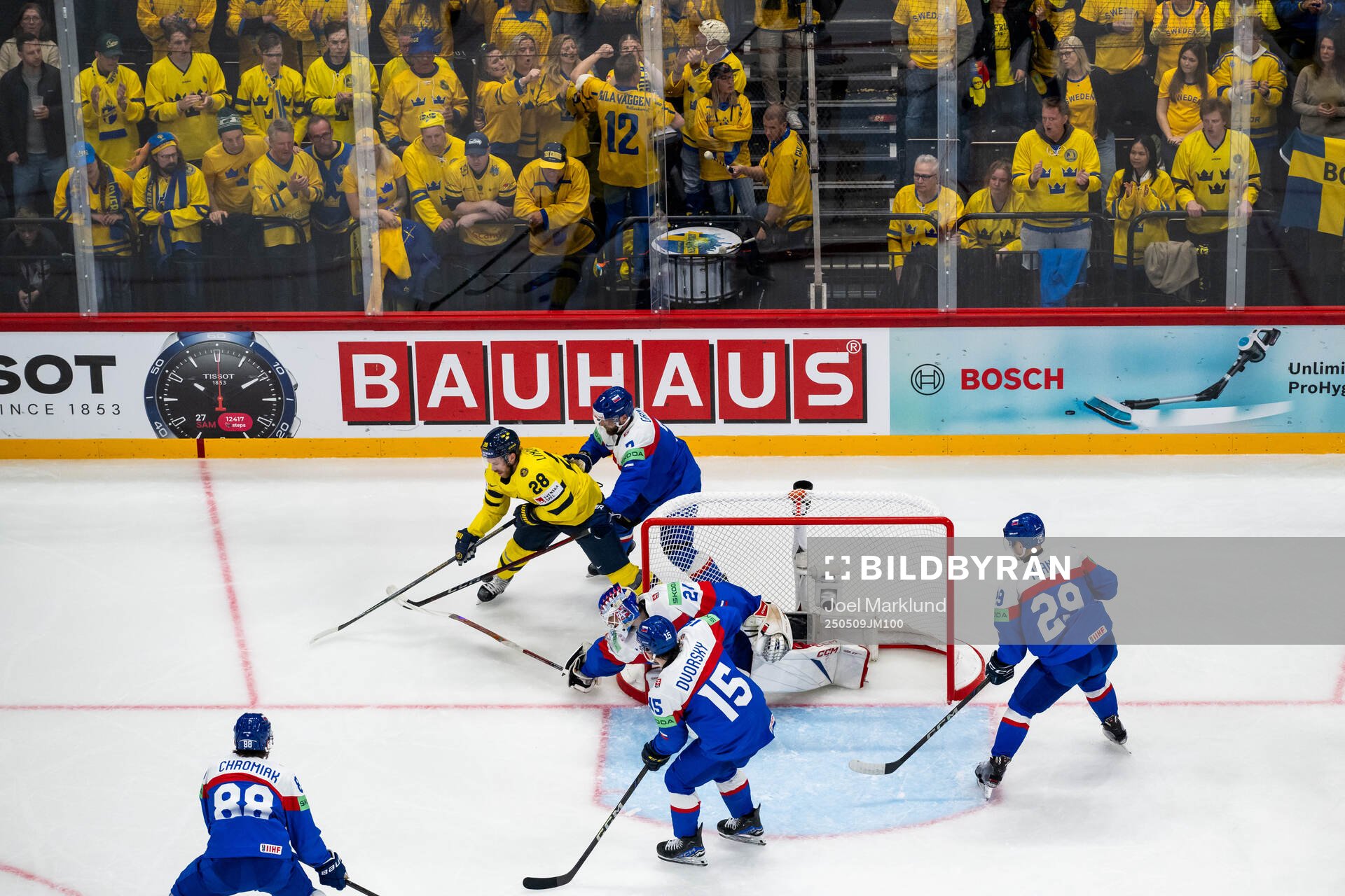 Elias Lindholm of Sweden competes for the puck with Mario
